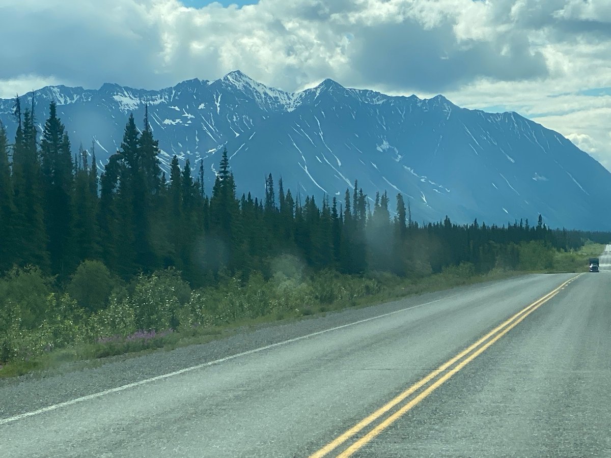 Empty two-lane highway curves through the Yukon wilderness