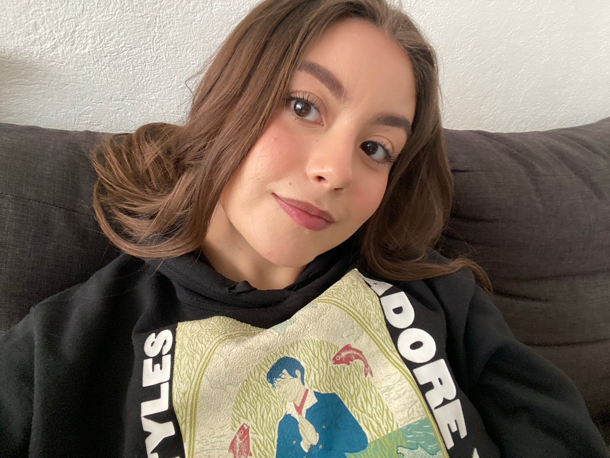 Woman takes selfies wearing Harry Styles merchandise hoodie
