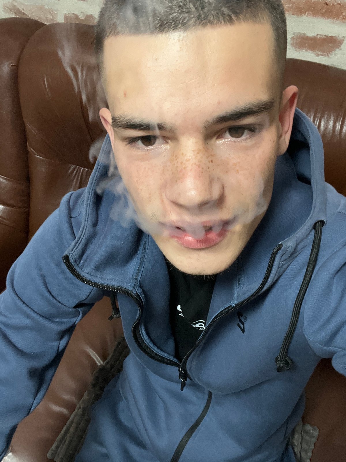 Young man smoking on couch indoors in Plovdiv