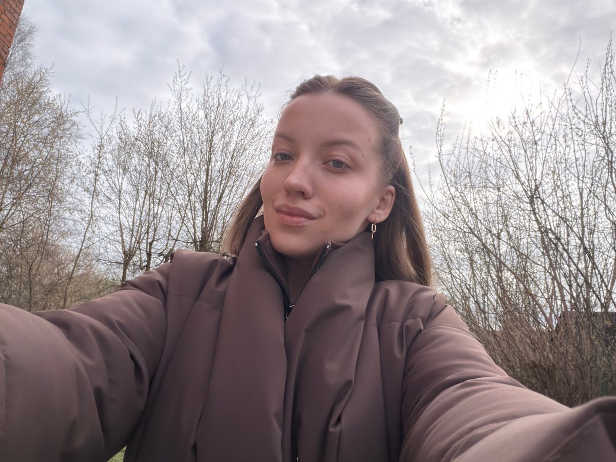 Woman takes selfie, walks outdoors in overcast Reshetnikovo morning