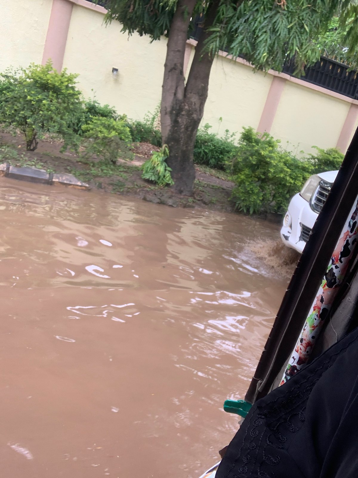Everyday life inside an Abuja home, flooding visible outside