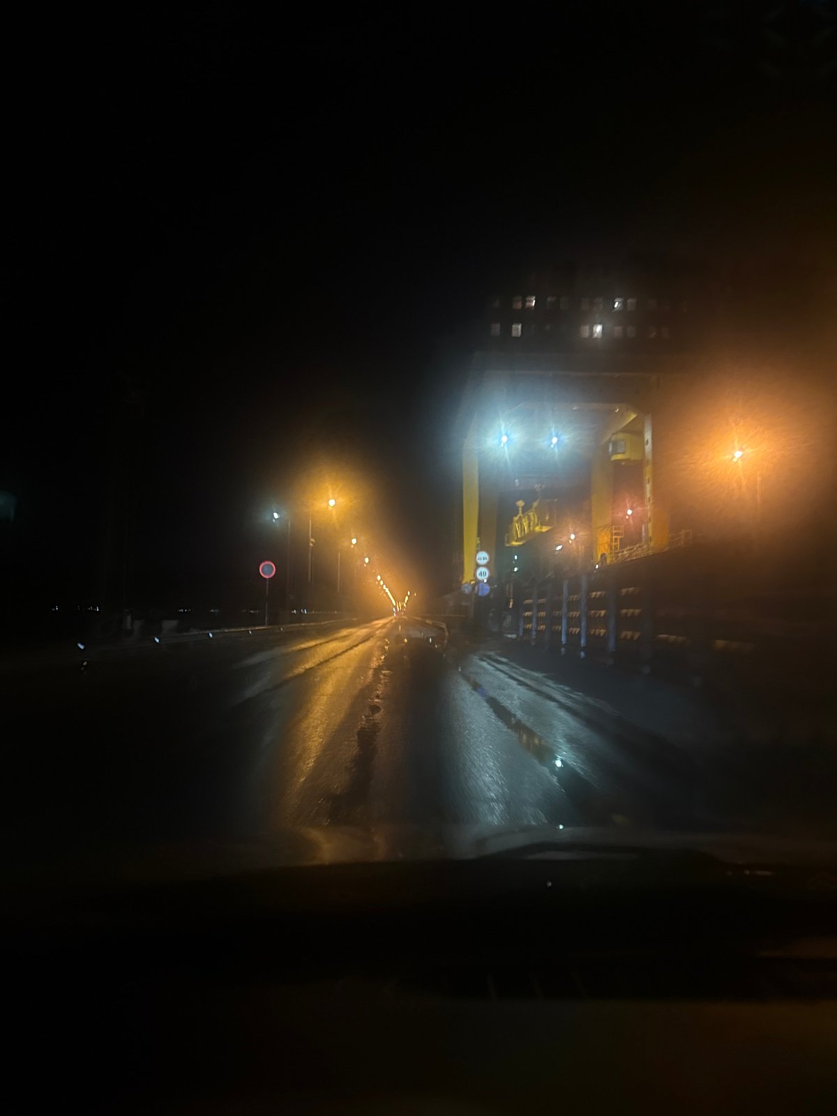 Wet nighttime street scene captured in Chaikovsky, Russia