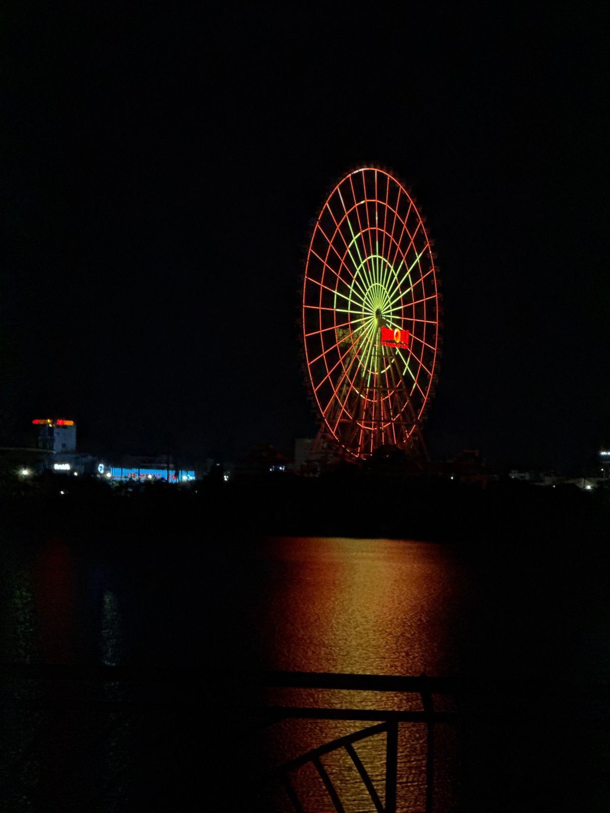 Nighttime scenes captured around illuminated Ferris wheel in Đà Nẵng