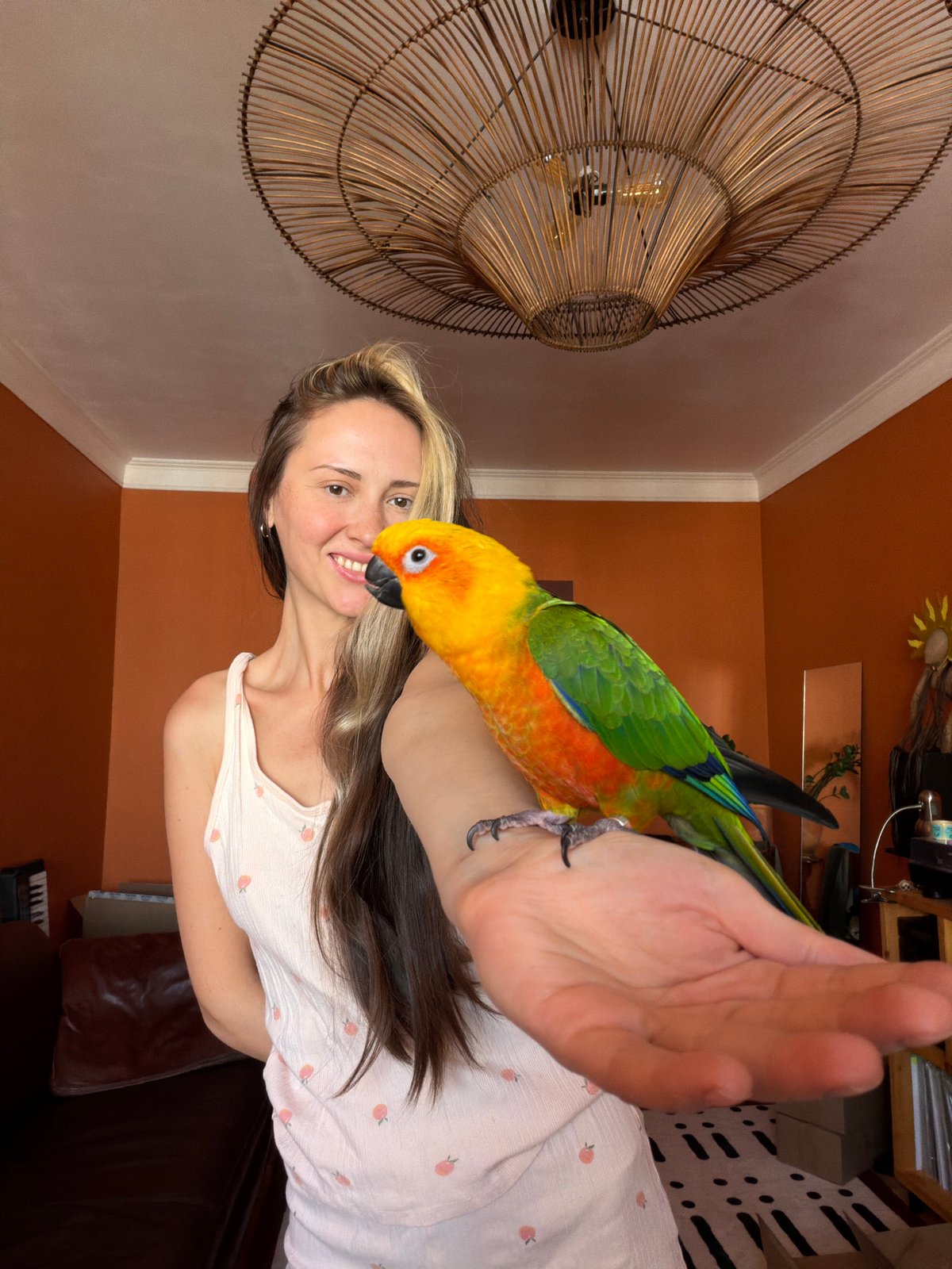 Woman poses with Sun Conure parrot in Khimki home