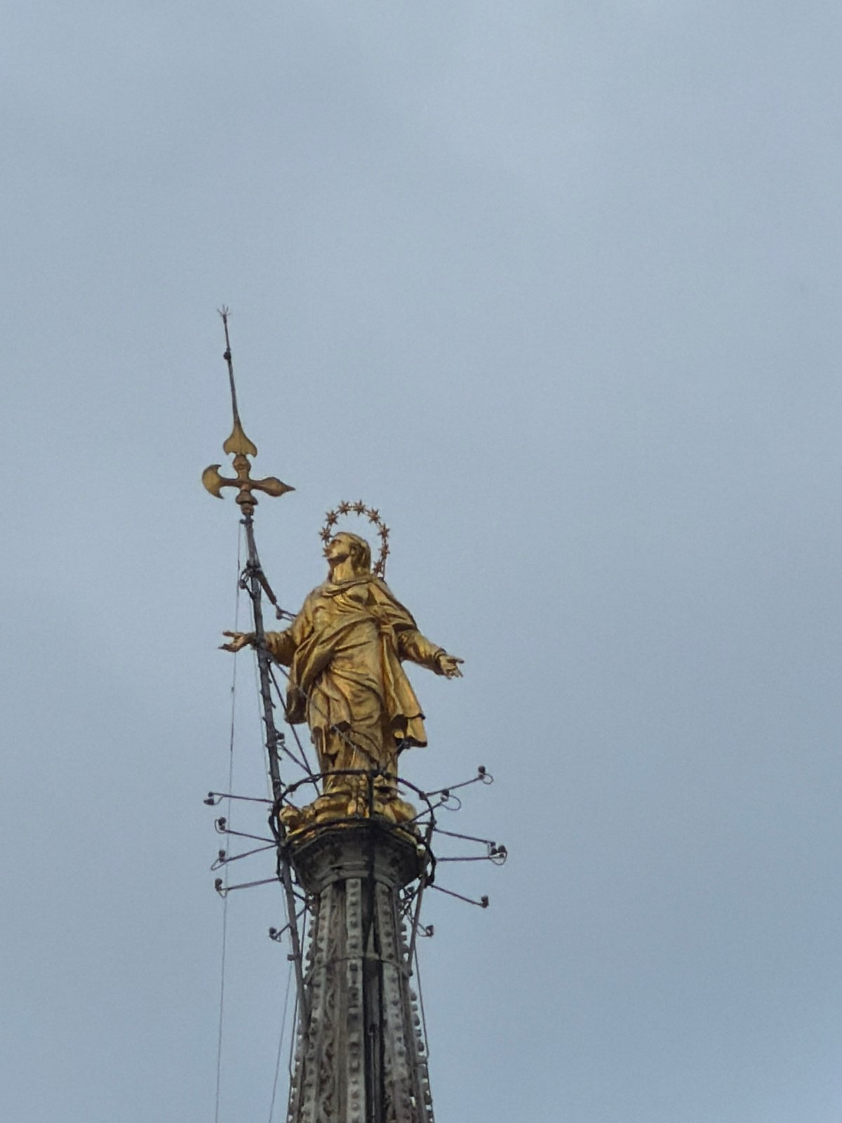 Visitor documents Milan Cathedral's Gothic details and golden Madonnina statue