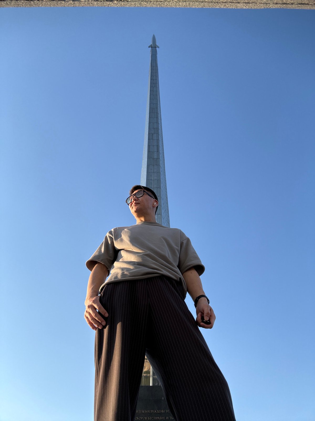 Tourist photographs space monuments in Moscow during afternoon visit