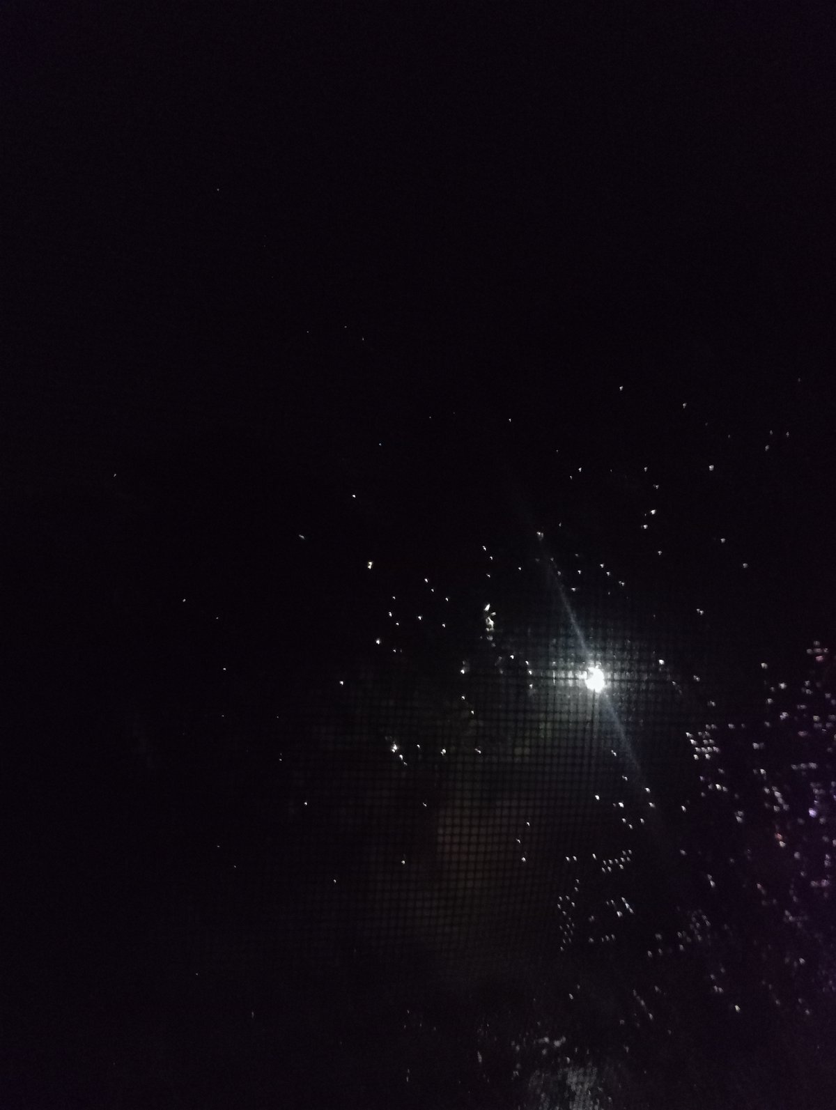 Rainy night scene captured through window in Nkpor, Nigeria