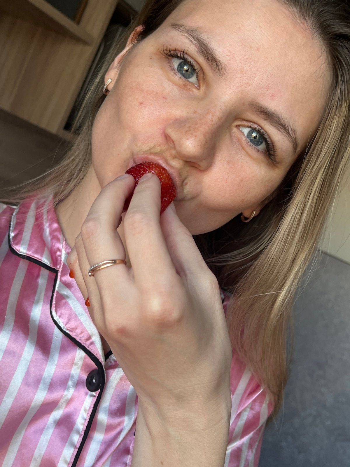 Woman enjoys early morning strawberry snack in Russian home