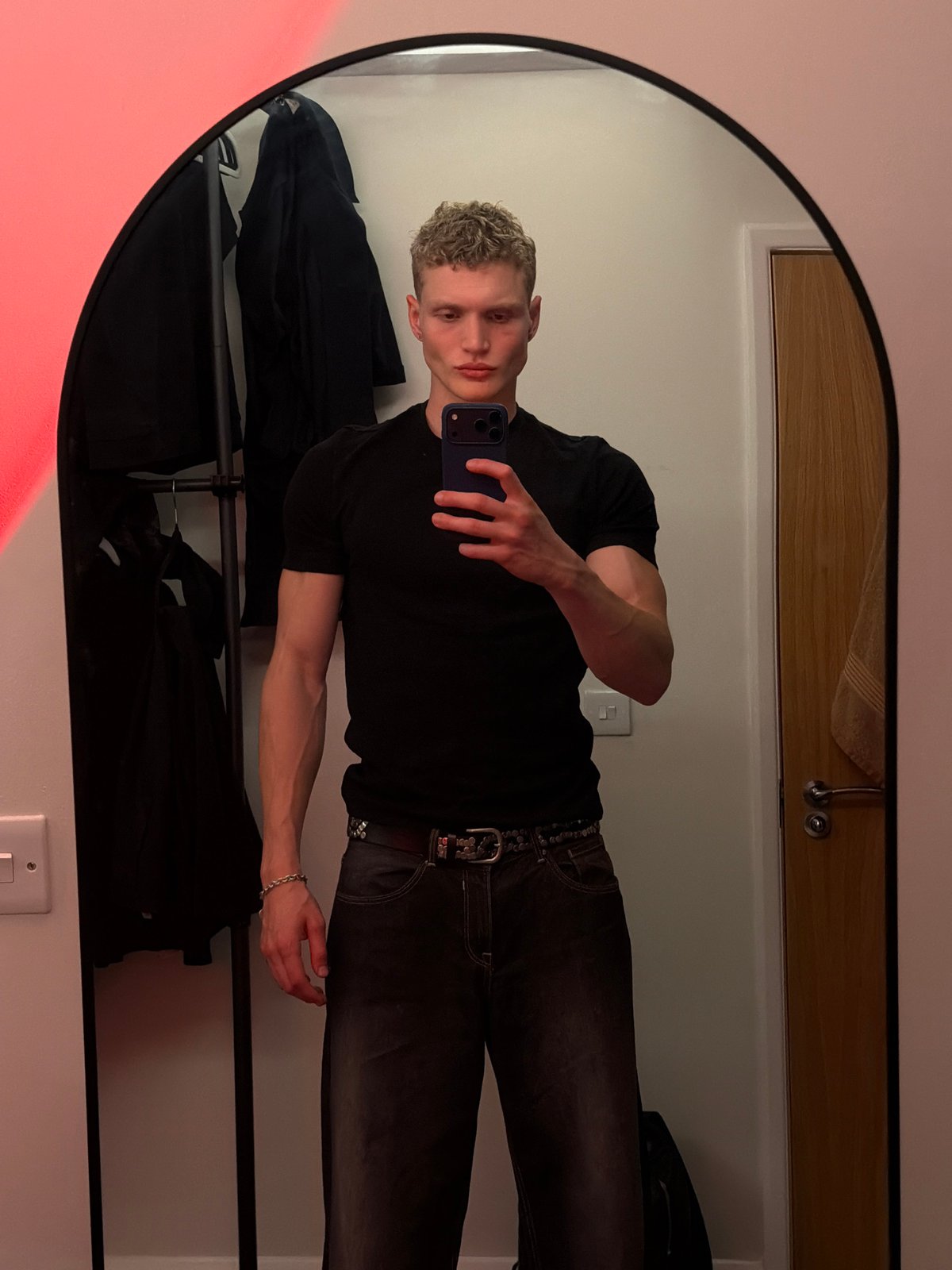 Mirror selfies in a red-lit London room, two minutes apart.