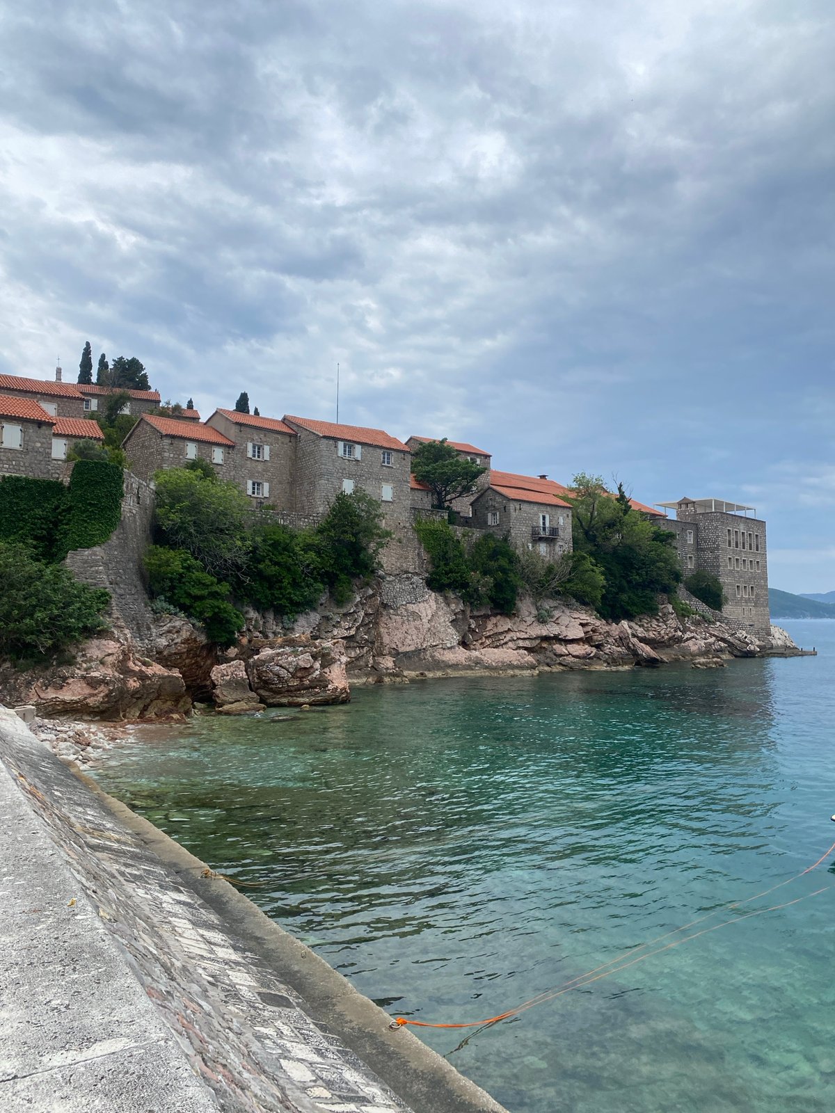 Tourists document scenic views of historic Sveti Stefan, Montenegro