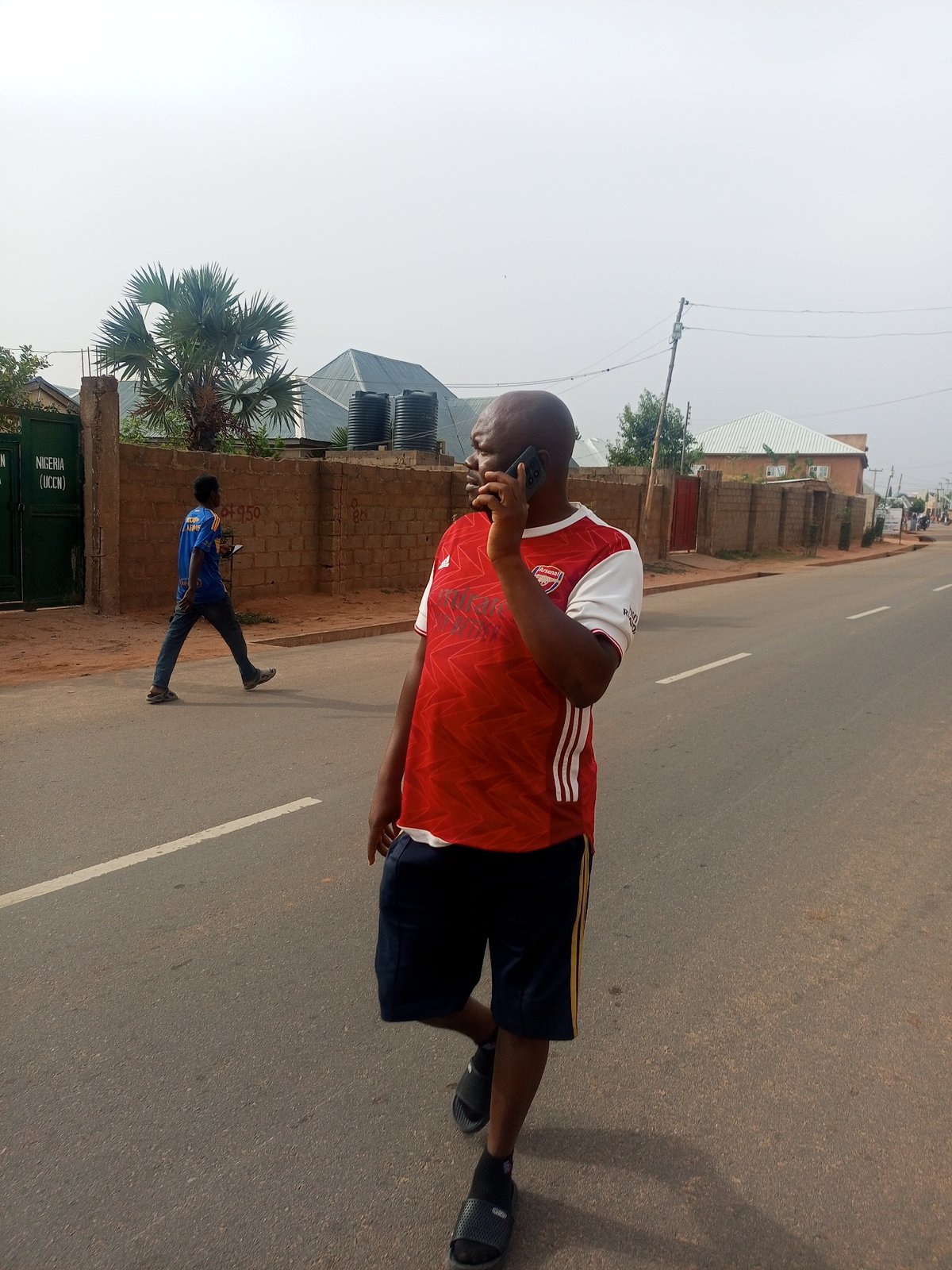Morning pedestrians navigate Tempure streets in traditional Nigerian town