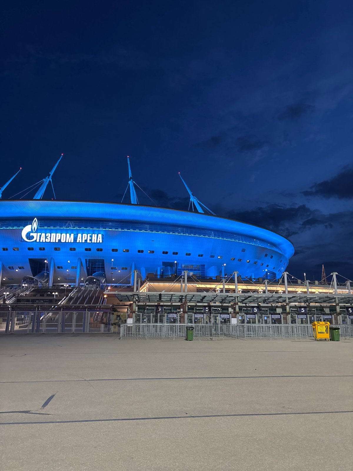 Gazprom Arena glows blue against dramatic evening sky
