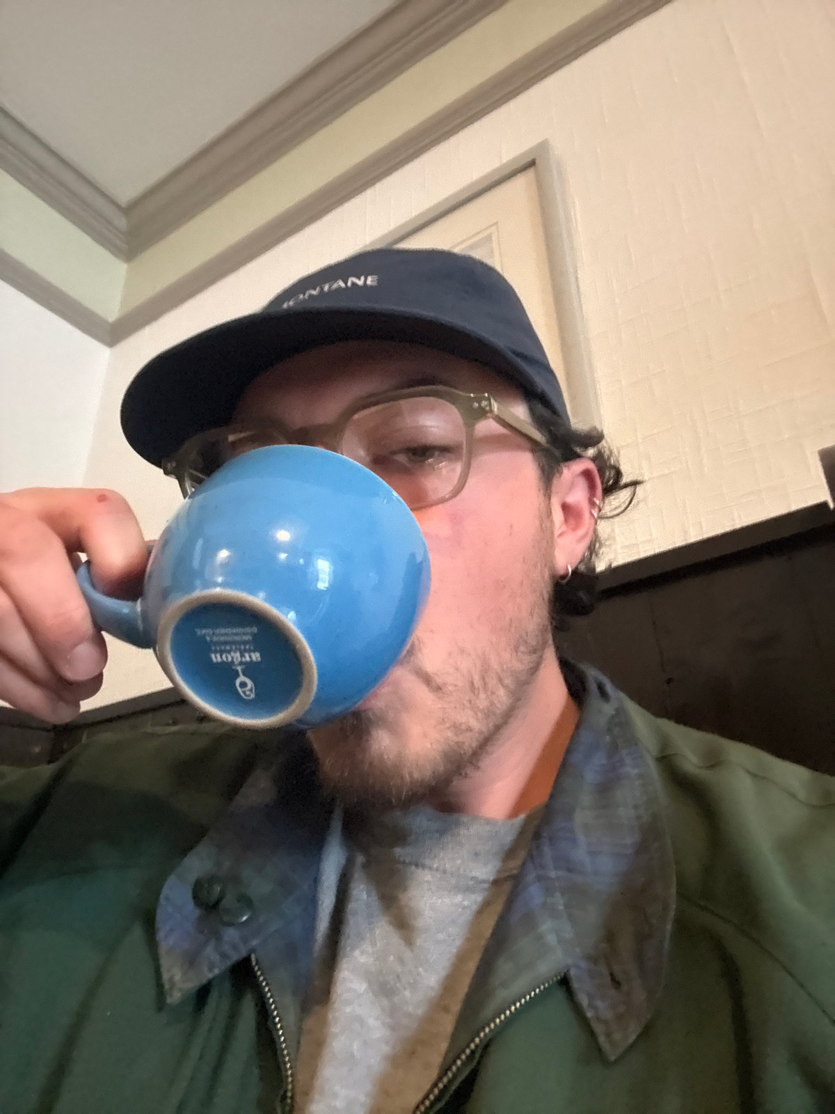 Group enjoys traditional breakfast at pub, man photographed with mug