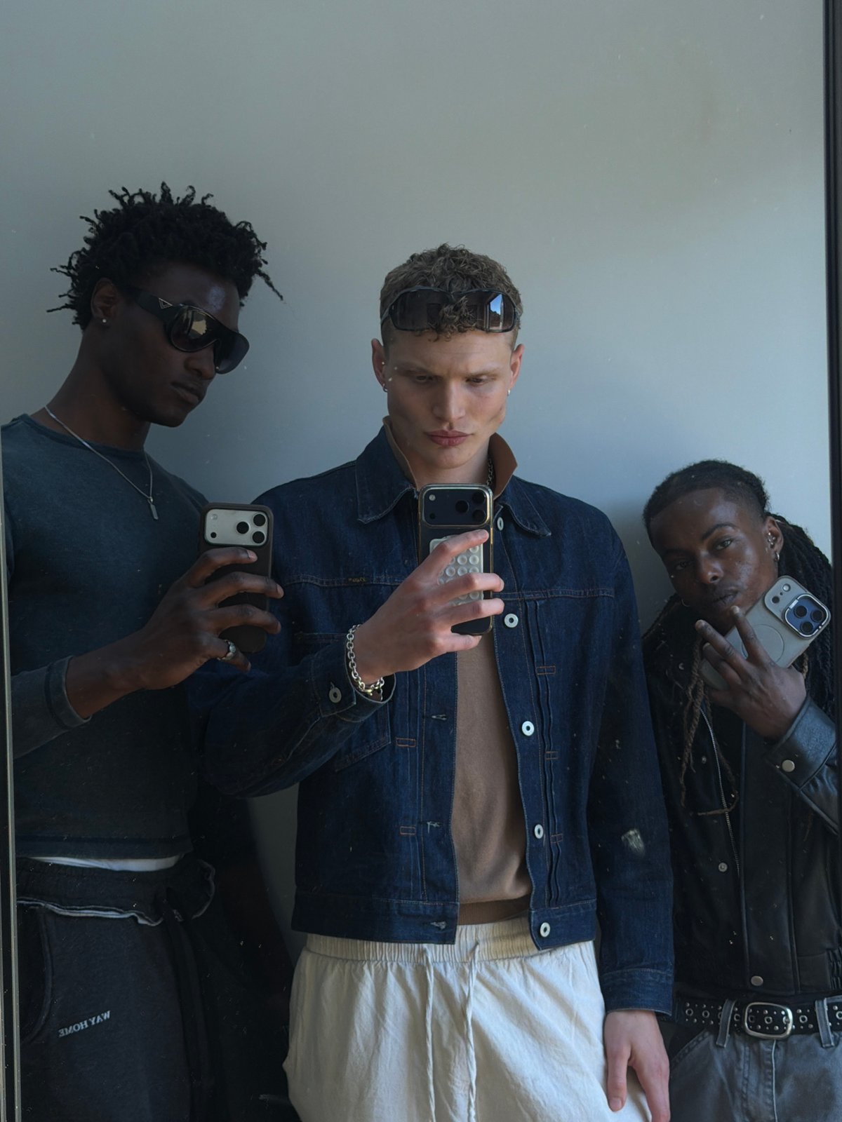 Three men take mirror selfies in London indoor location