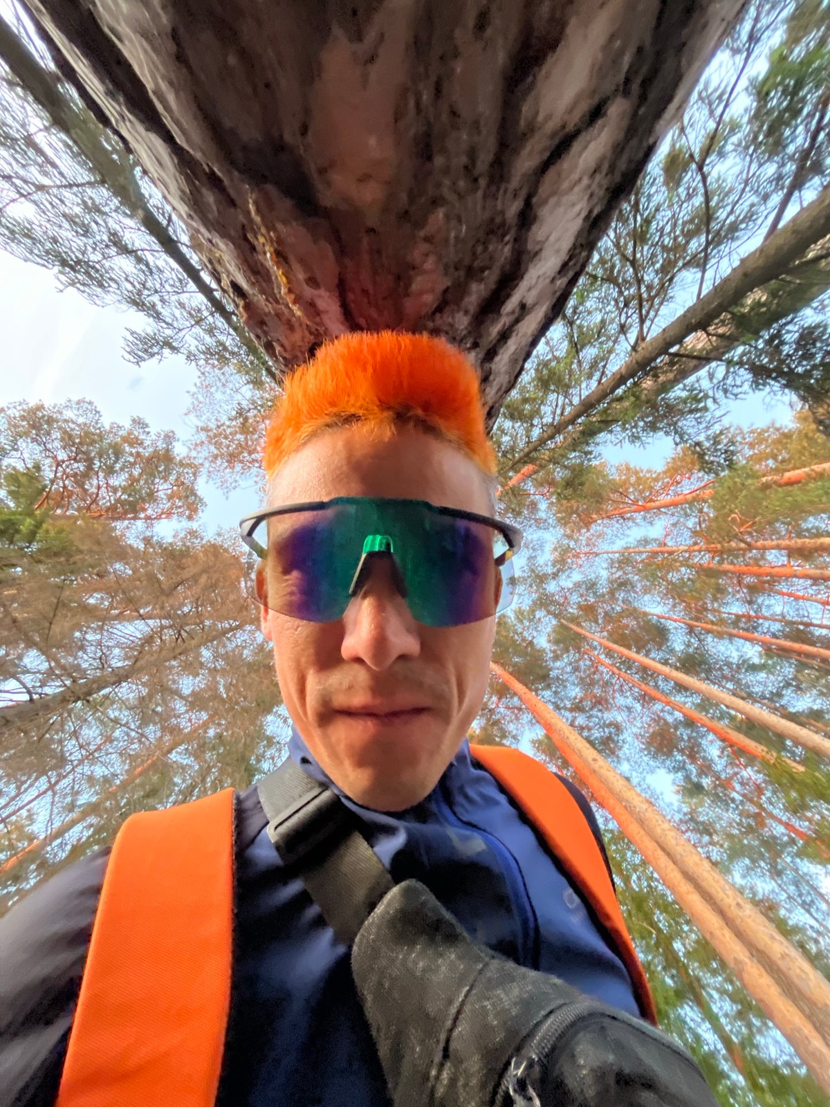 Orange-haired cyclist photographed in Chaikovsky forest with red bicycle