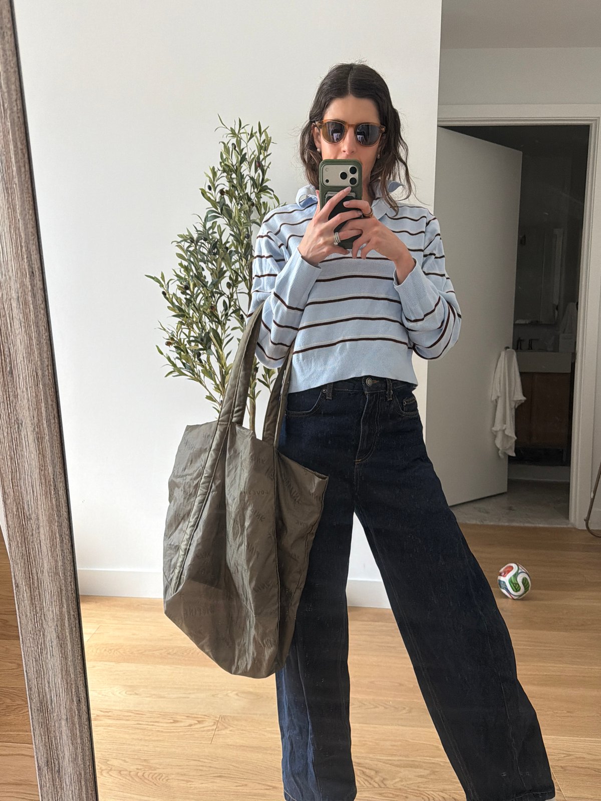 Woman takes mirror selfie with green phone case in New York