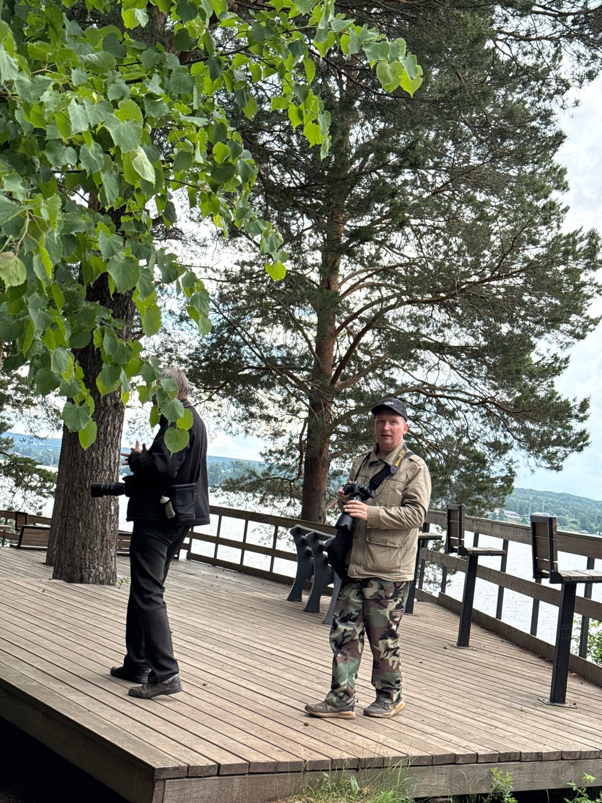 Men photograph scenic Votkinsk Reservoir overlook on overcast morning