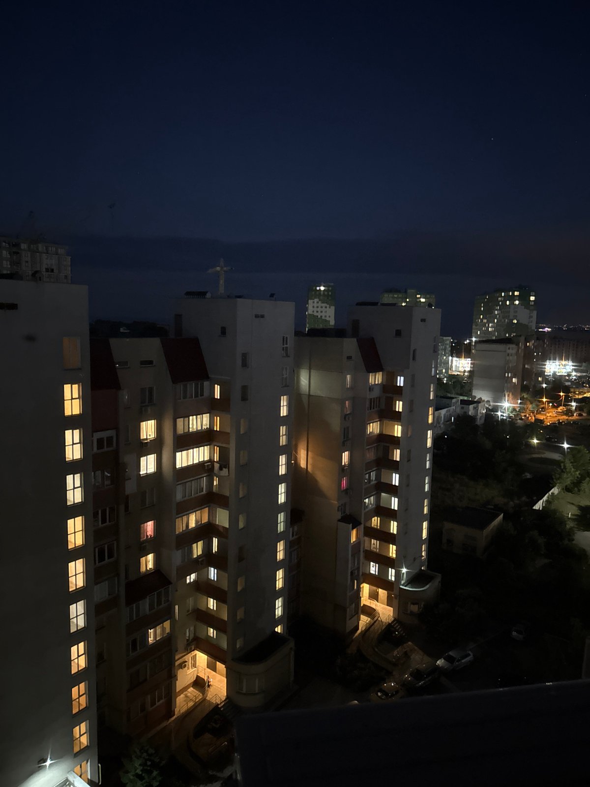 Orange moon rises over Odesa apartments on a summer night