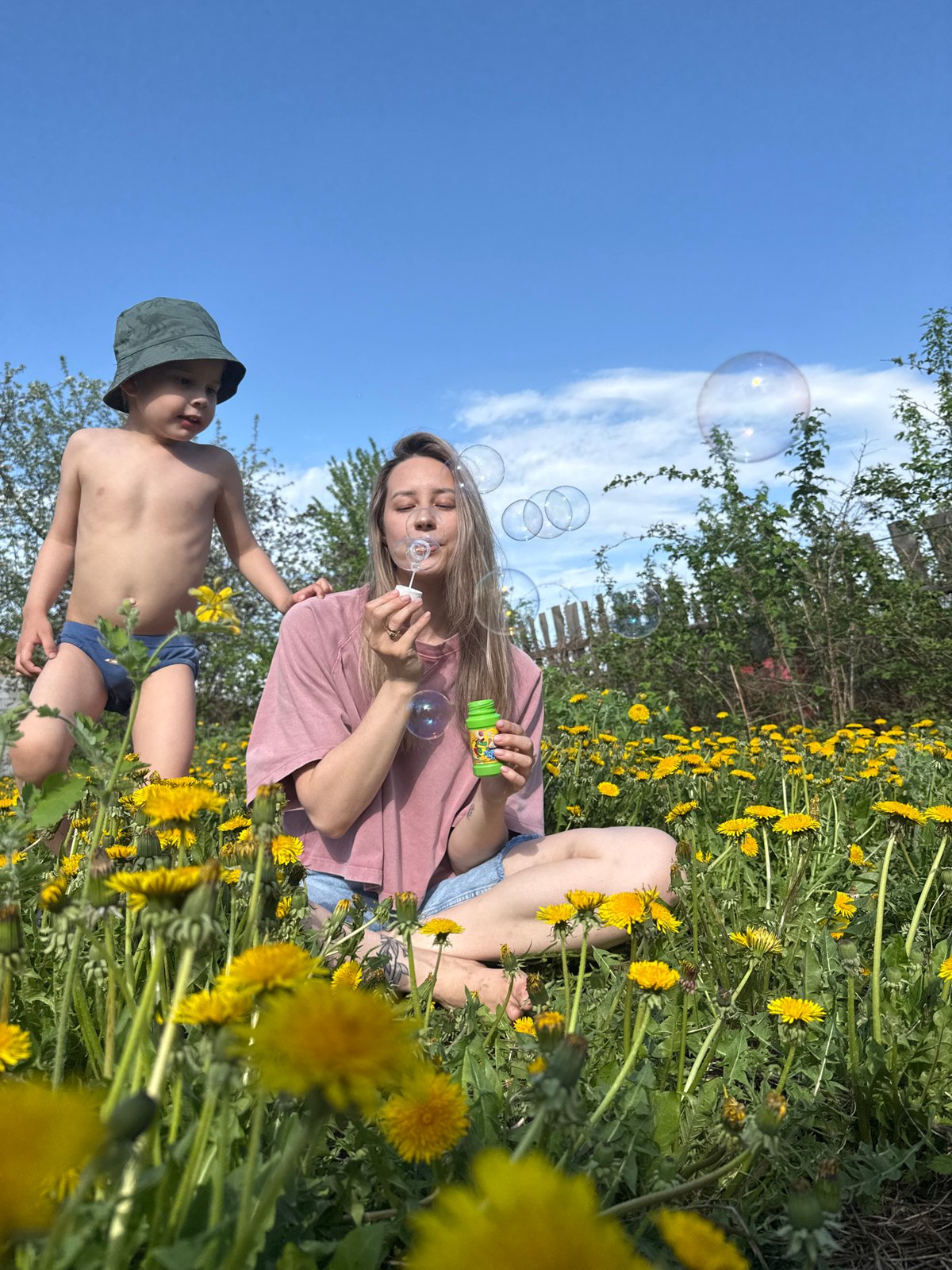Woman and child enjoy dandelion field moment in Chaikovsky