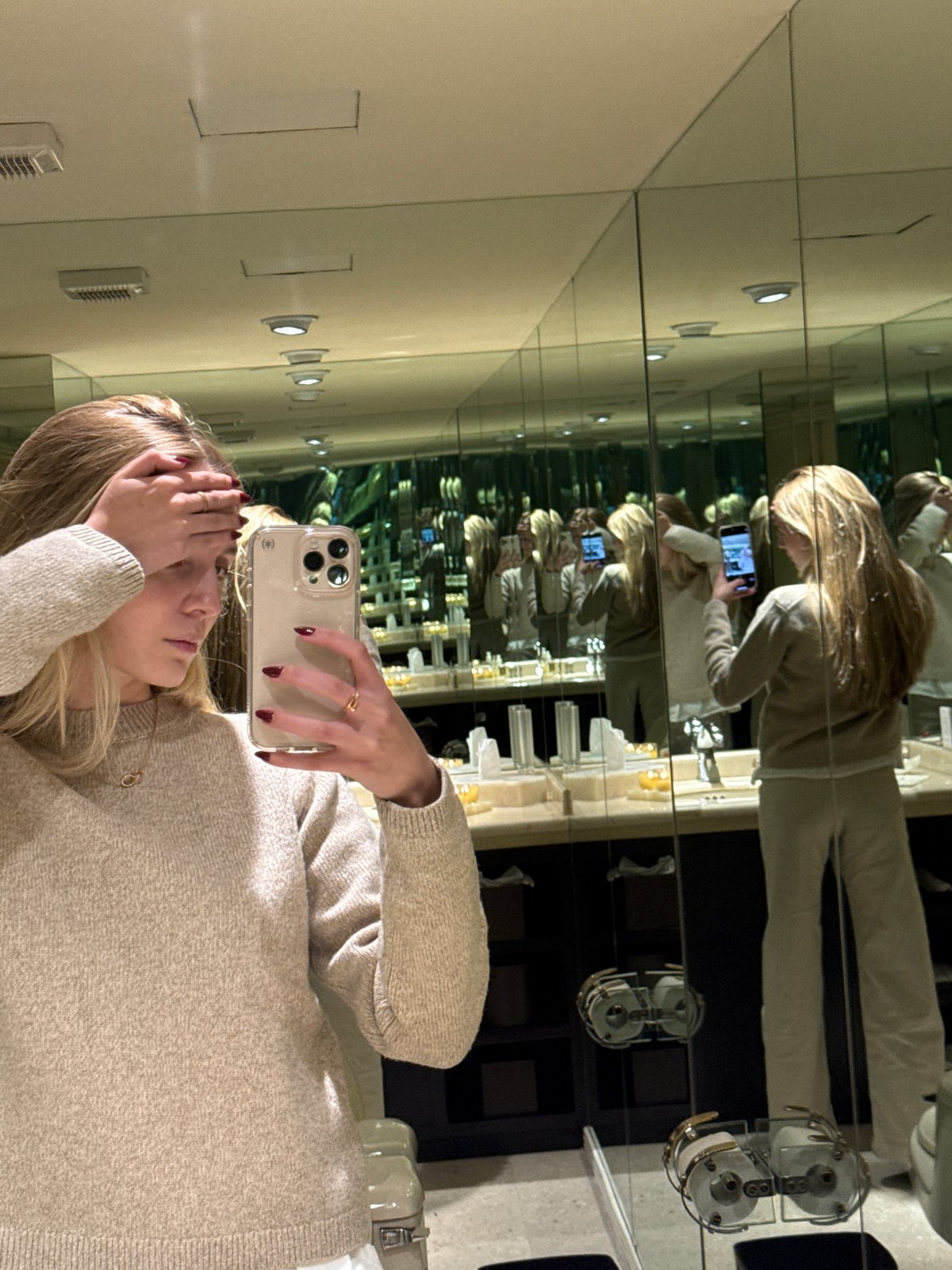 Woman takes mirror selfie in candlelit bathroom in Mexico City