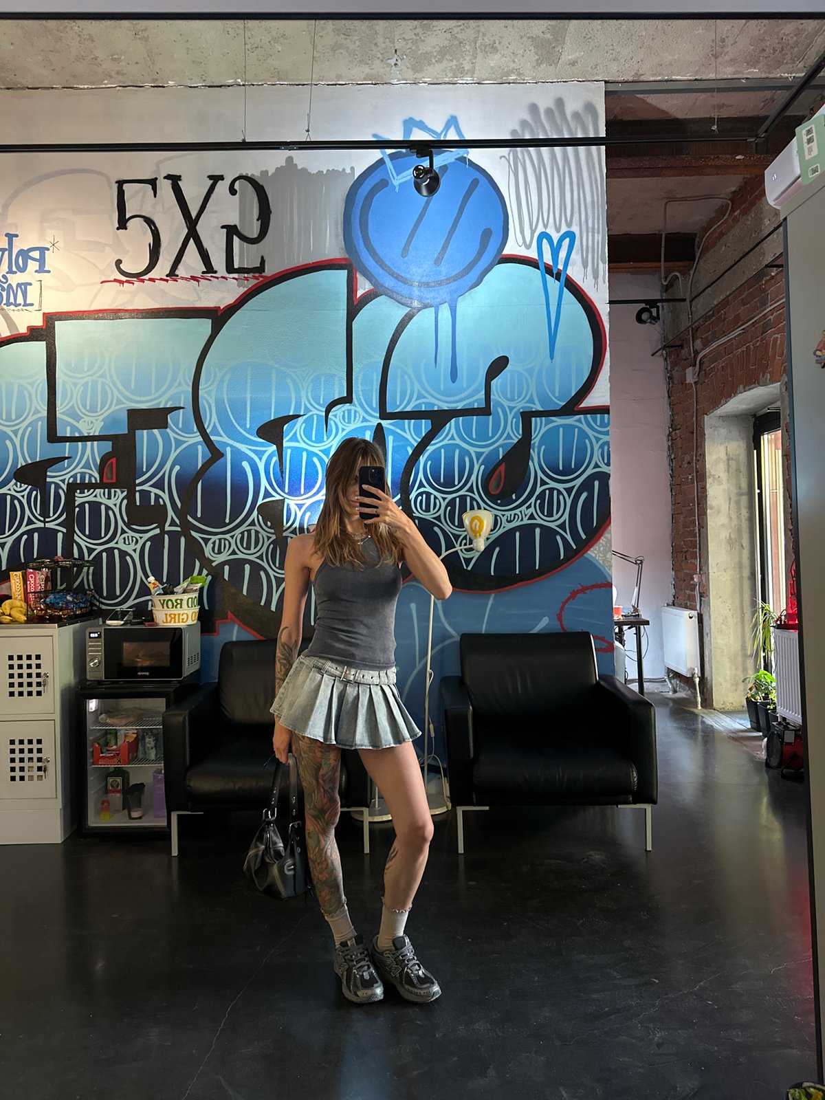 Woman takes selfies at graffiti-covered Moscow tattoo studio