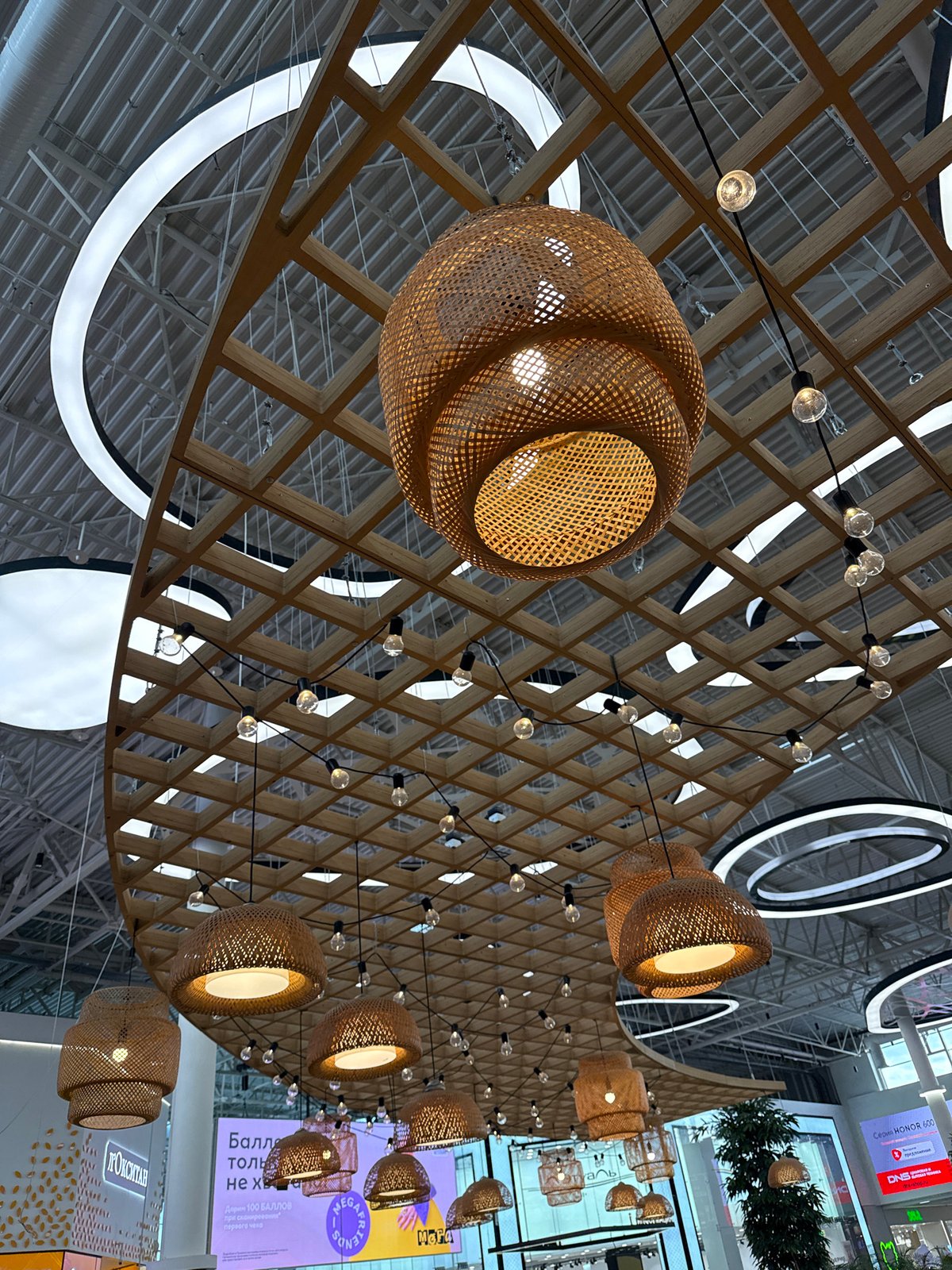 Shopper documents modern mall interior and toy train in Kudrovo