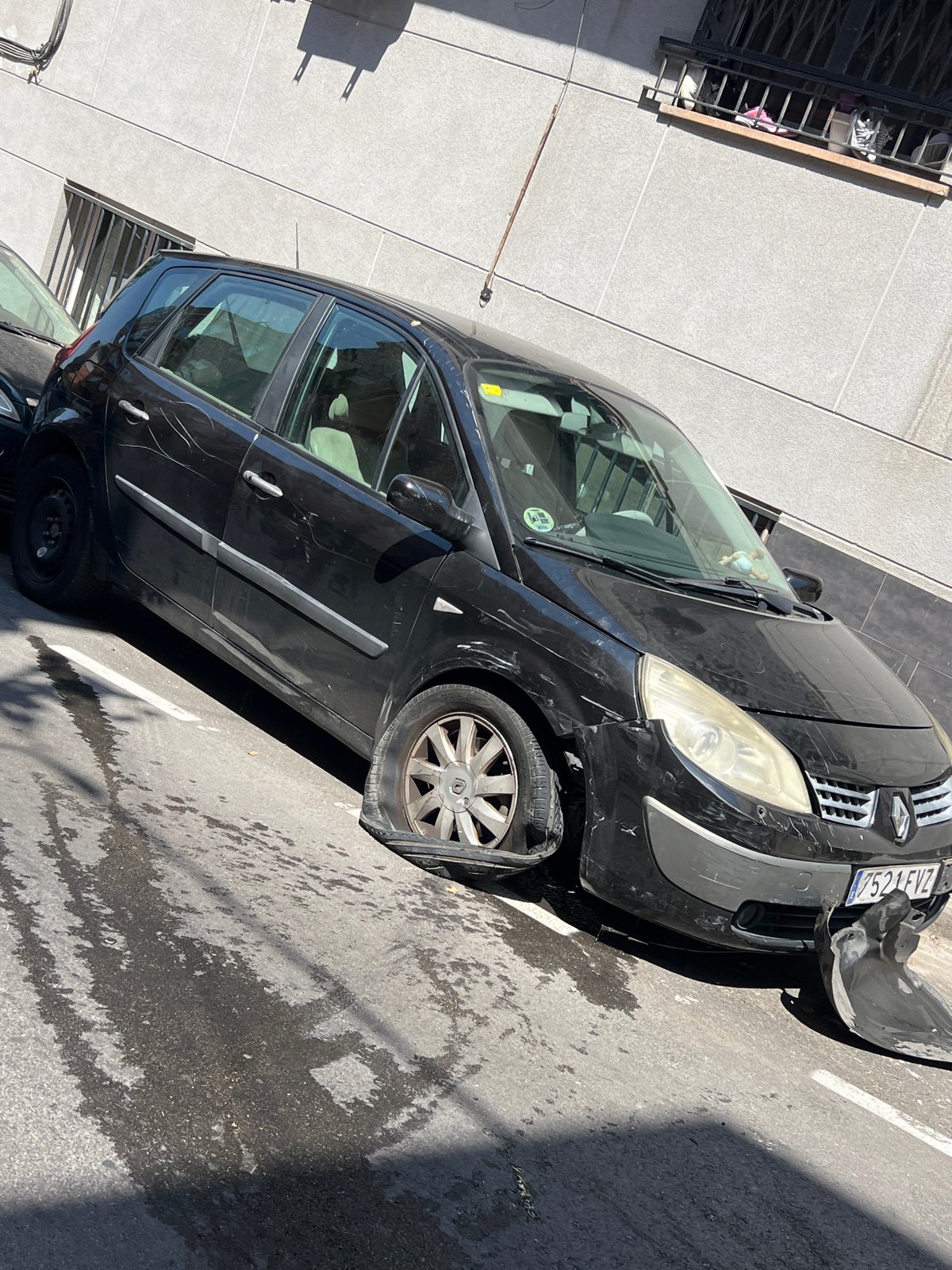 Damaged Renault Scenic with flat tire and detached fender in Santa Coloma