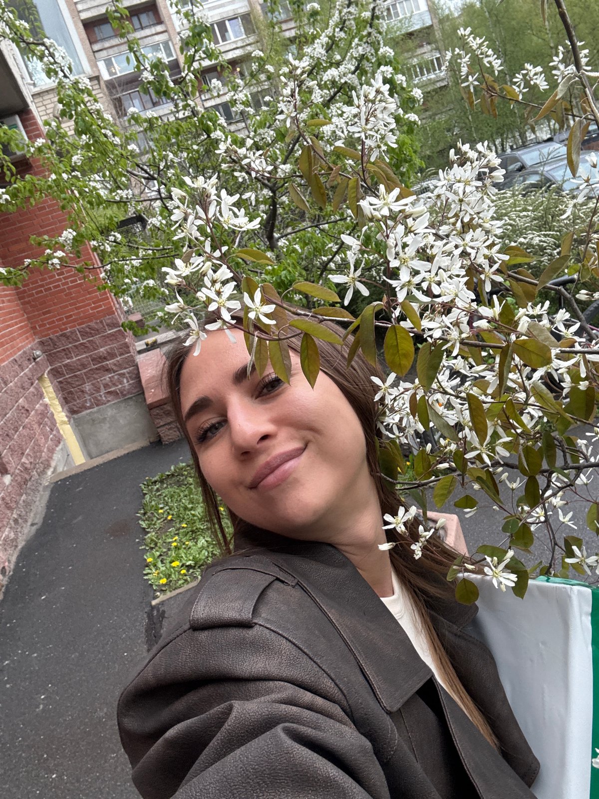 Woman enjoys spring blossoms near Saint Petersburg buildings