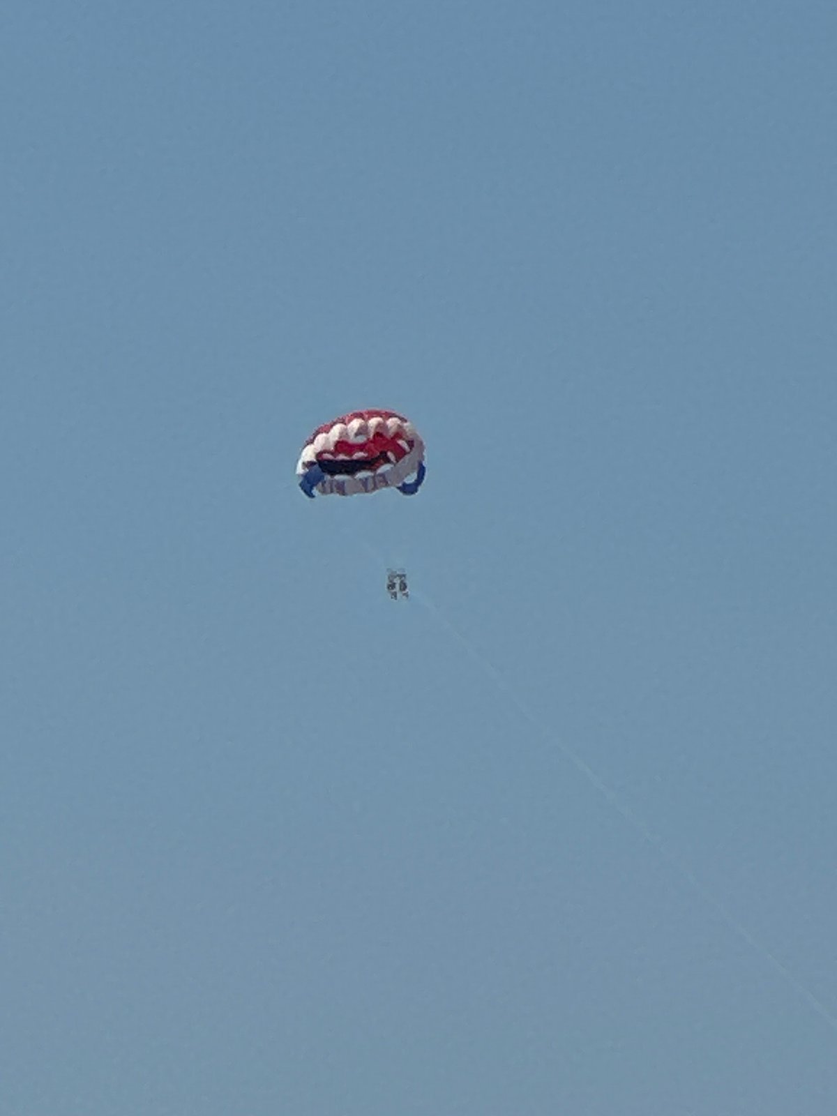 Colorful parachute drifts through the sky above Budva, Montenegro