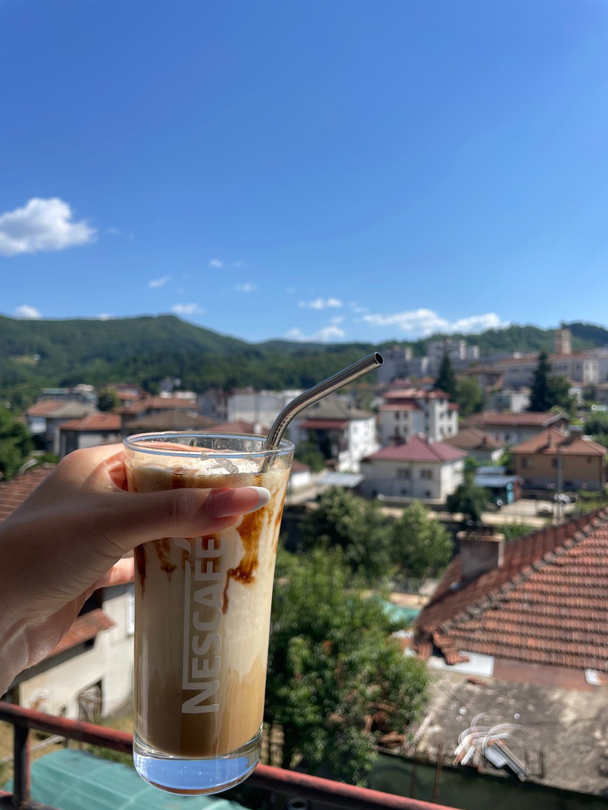 Balcony reading session in Zlatograd with iced coffee and Colleen Hoover