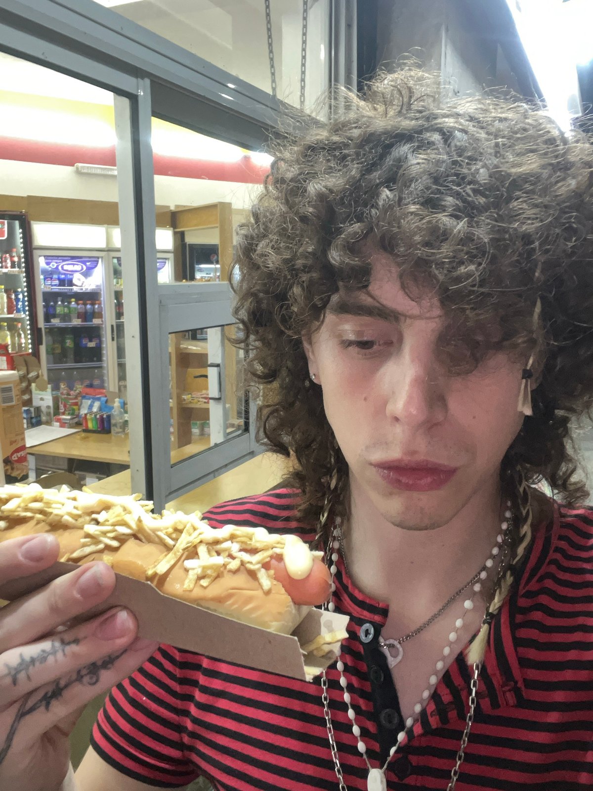 Concertgoer enjoys hot dog during live music performance in Buenos Aires