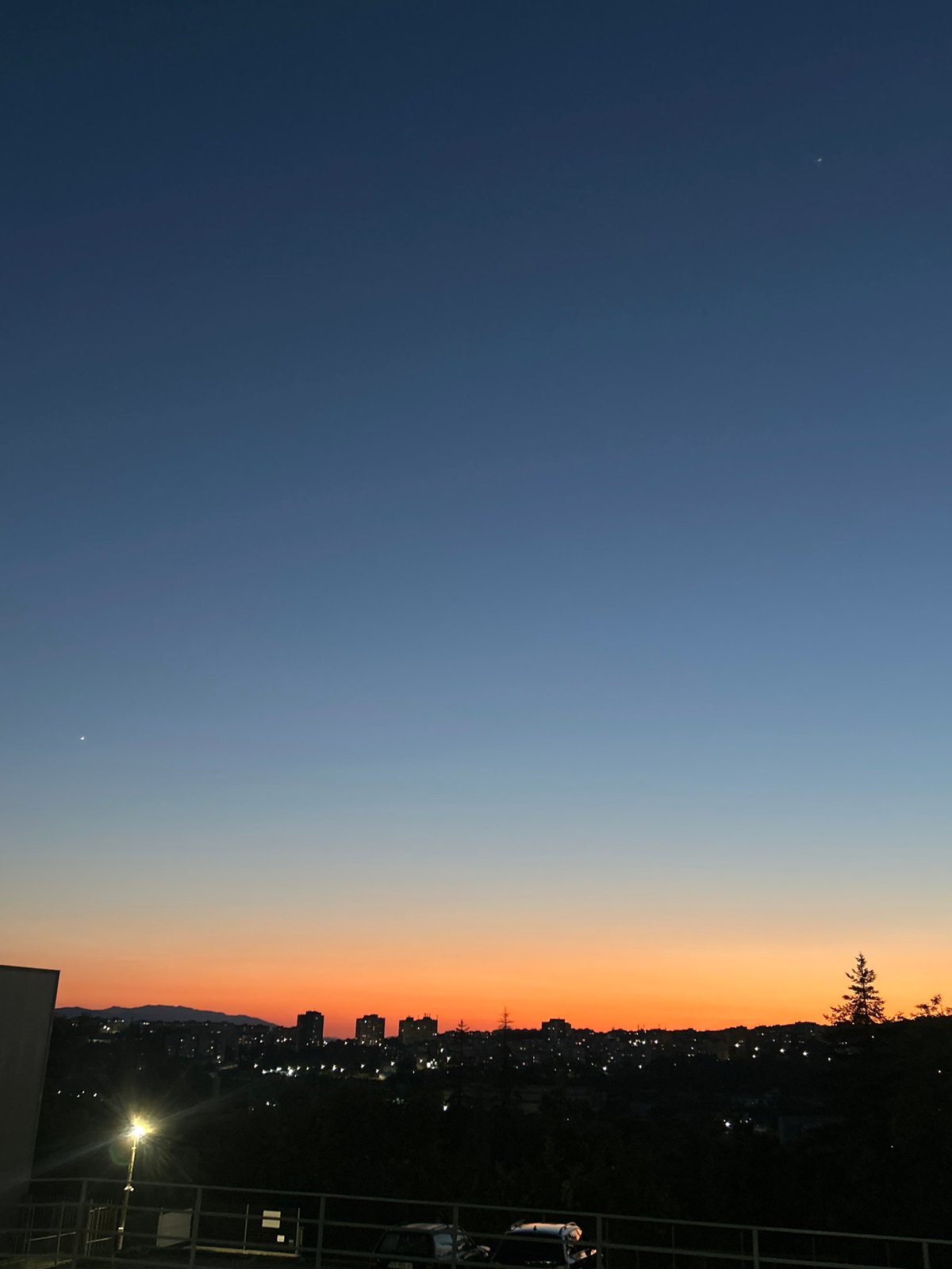 City skyline silhouetted against a dusk gradient sky