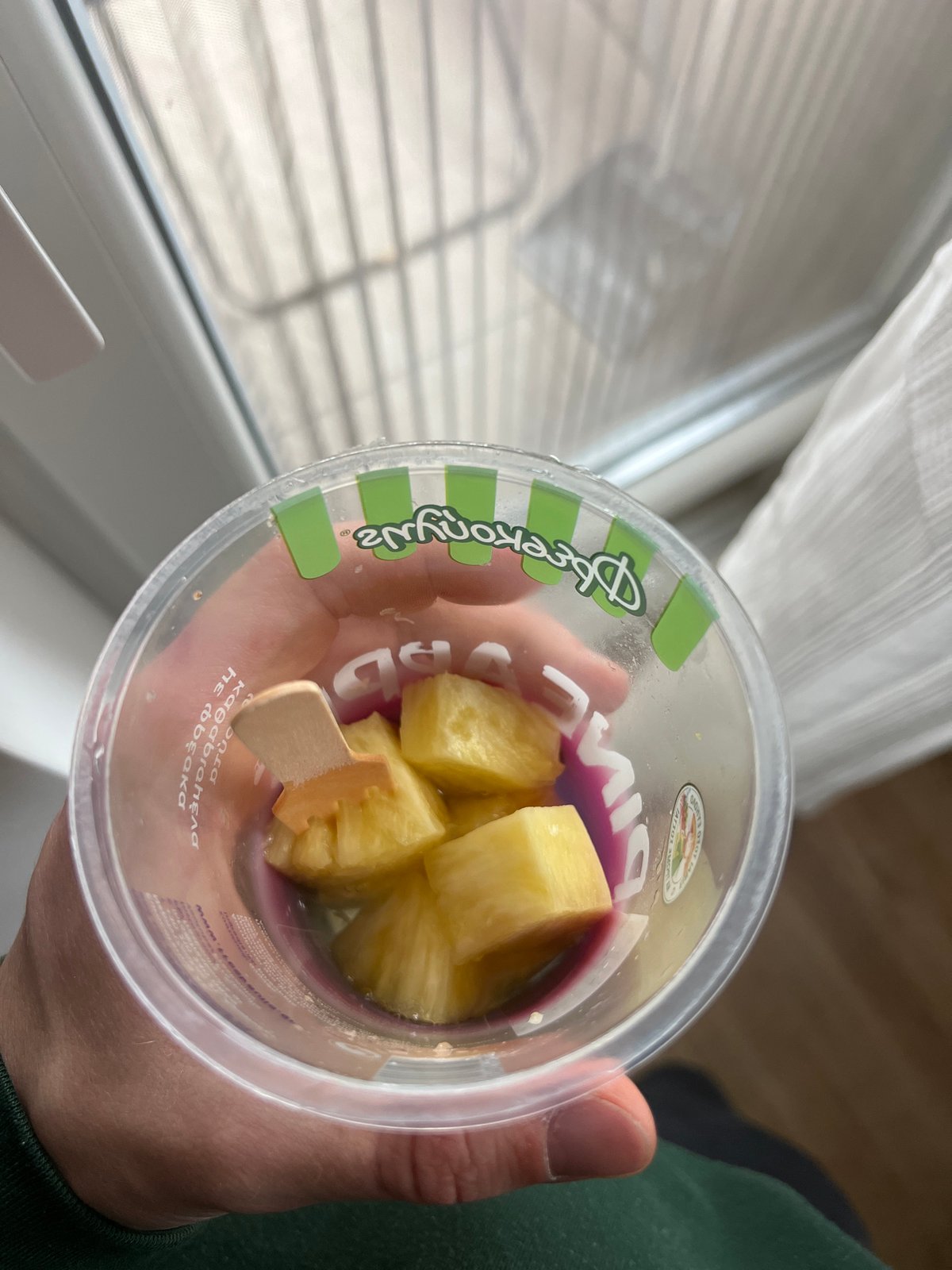 Person holds pineapple container with purple liquid in Burgas
