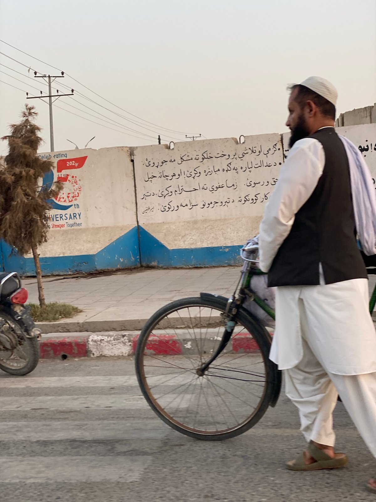 Street life in Kandahar: foot traffic, bikes, and a rickshaw