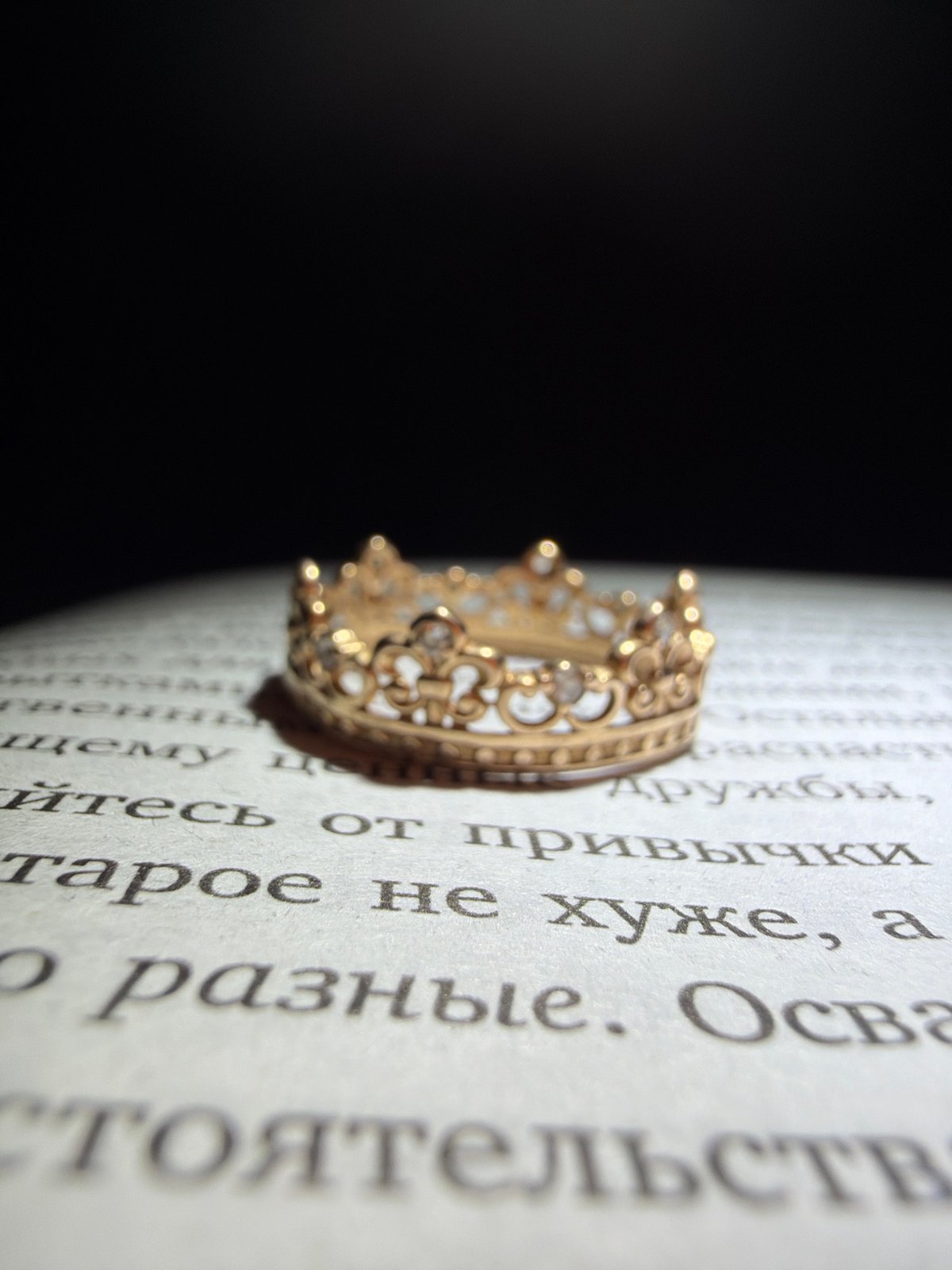 Crown-shaped rings staged on a Russian book, heart shadows included.