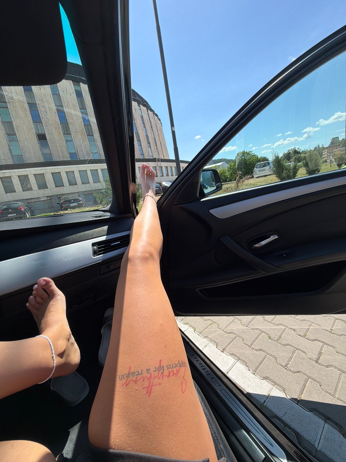 Legs out of a car door, tattoo partially visible, Gabrovo