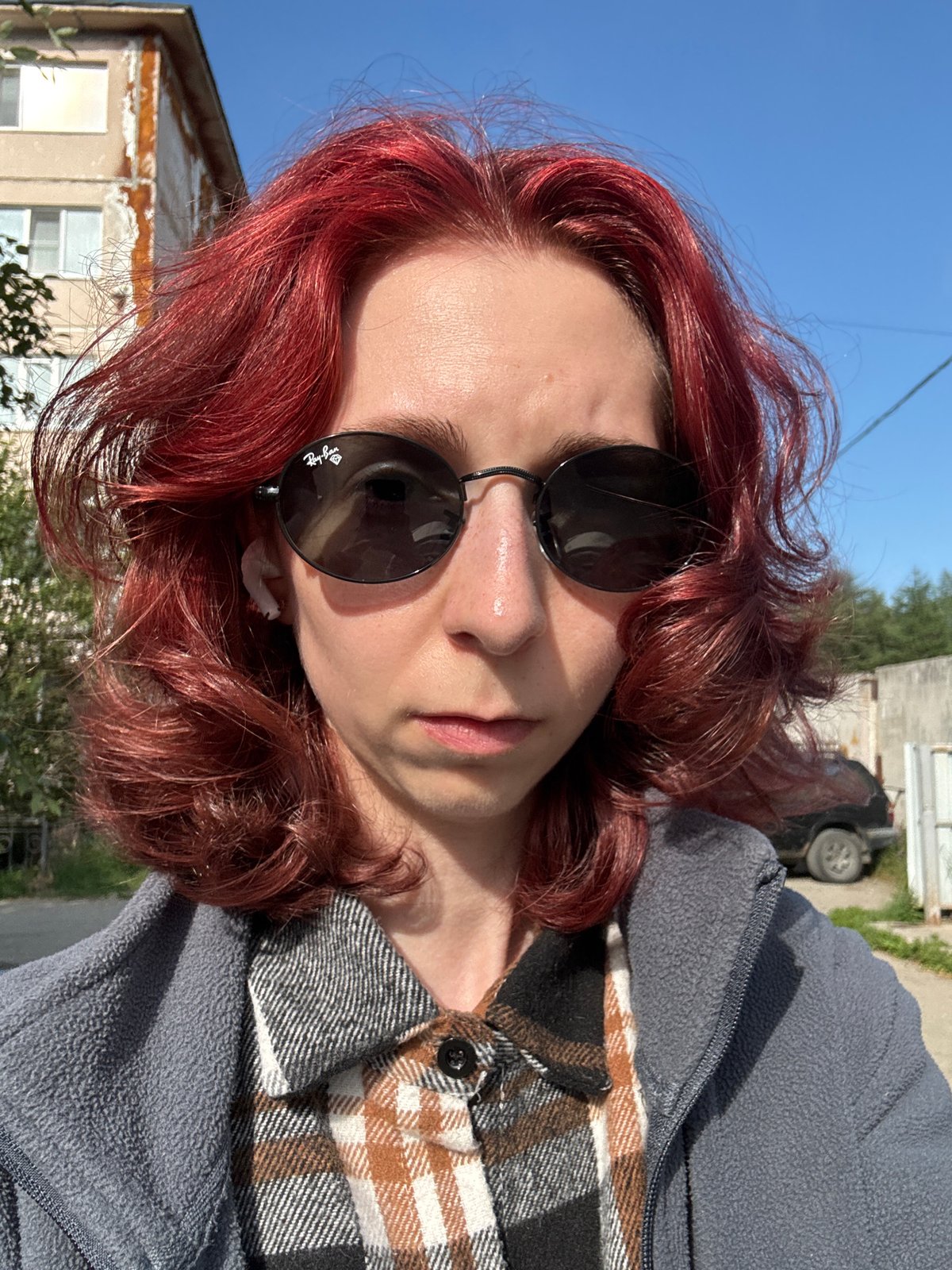 Red-haired selfie series outside a residential building