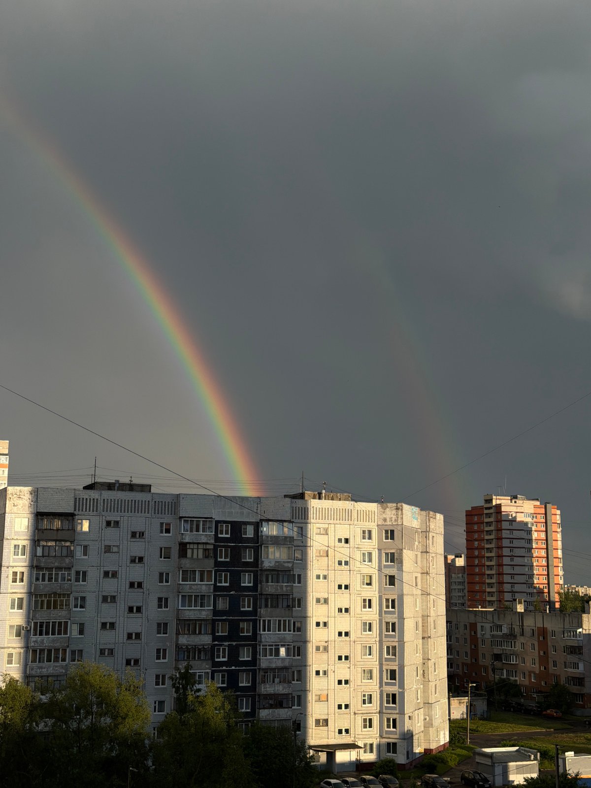 Double rainbow over wet streets in Rusanovo after summer rain