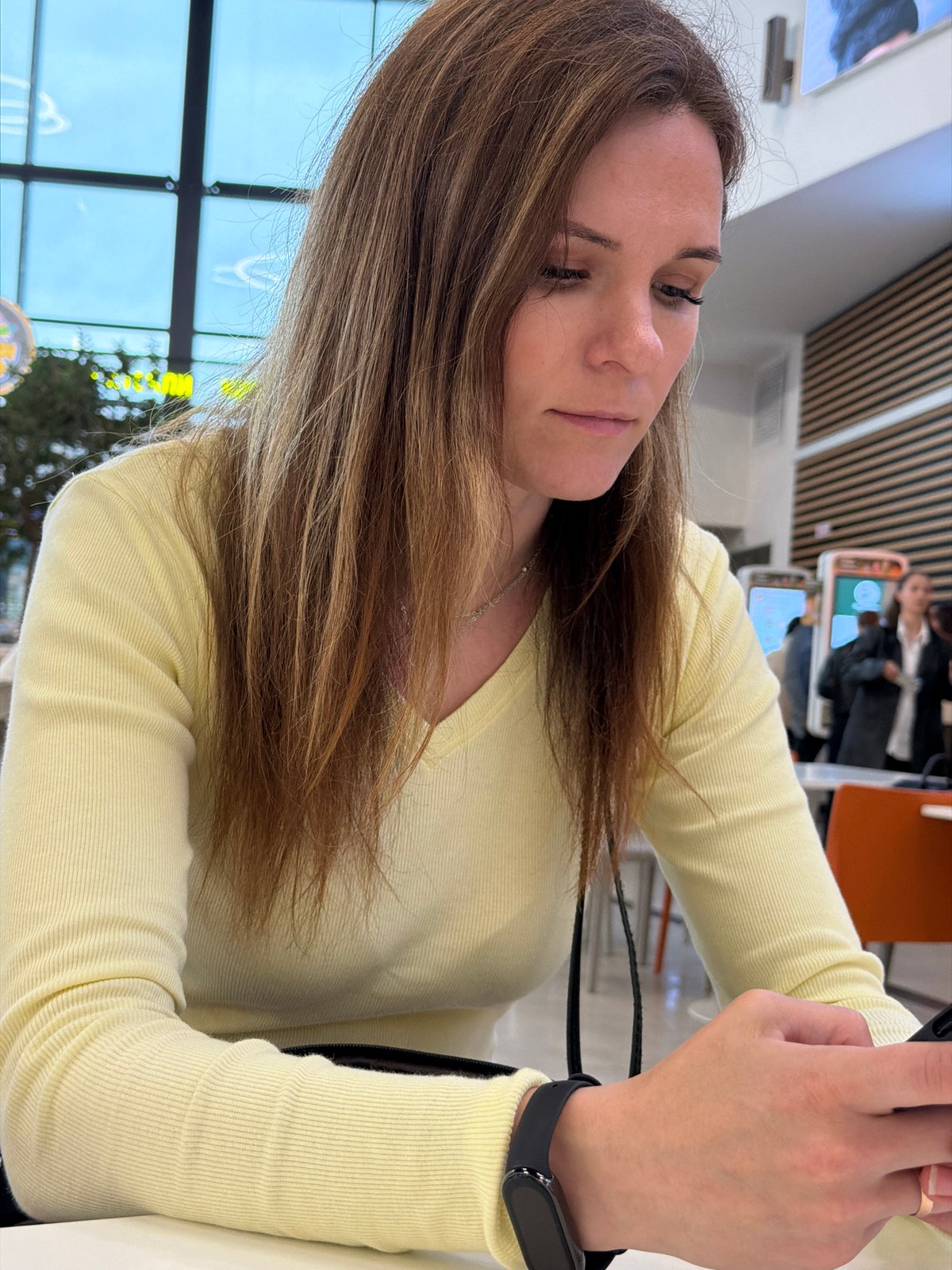 Scrolling through a phone at a Perm food court