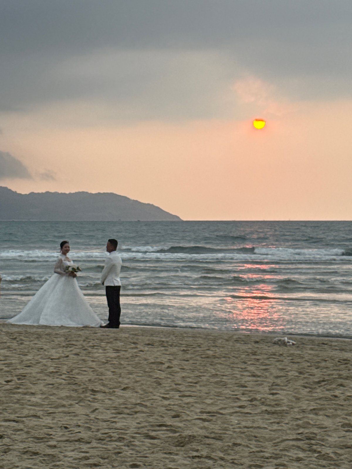 Wedding couple photographs on Đà Nẵng beach at sunset