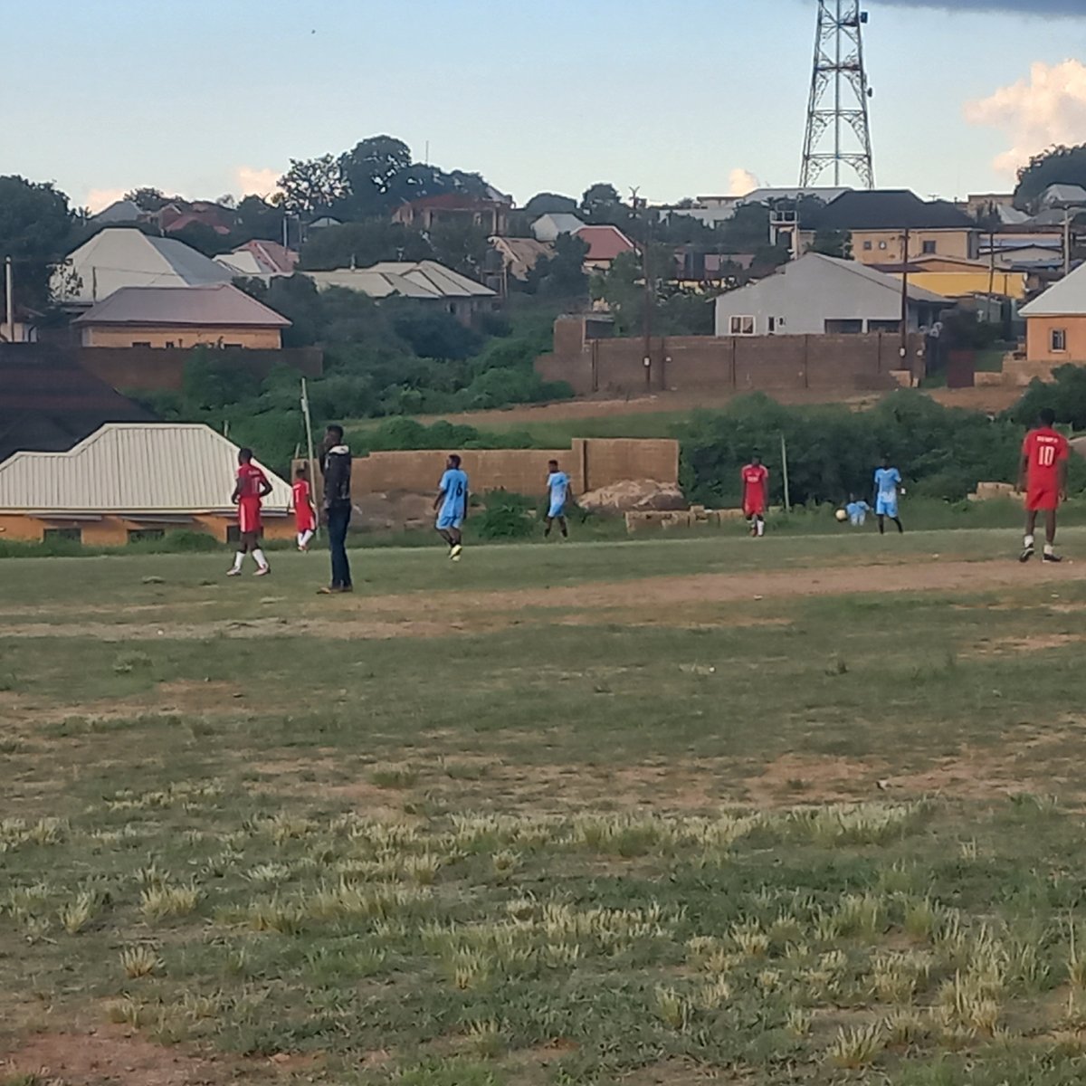 Football match on a dusty Jos pitch, New Hope Academy in red