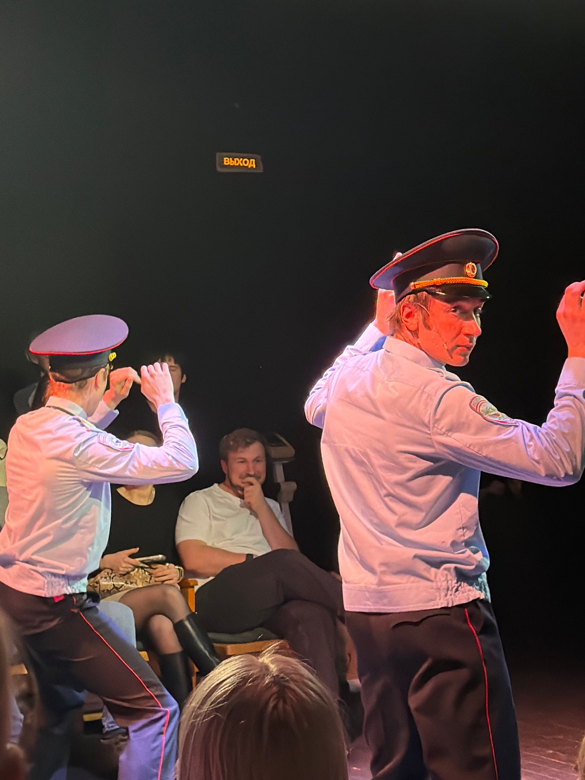 Indoor theatrical performance documented in dim lighting venue