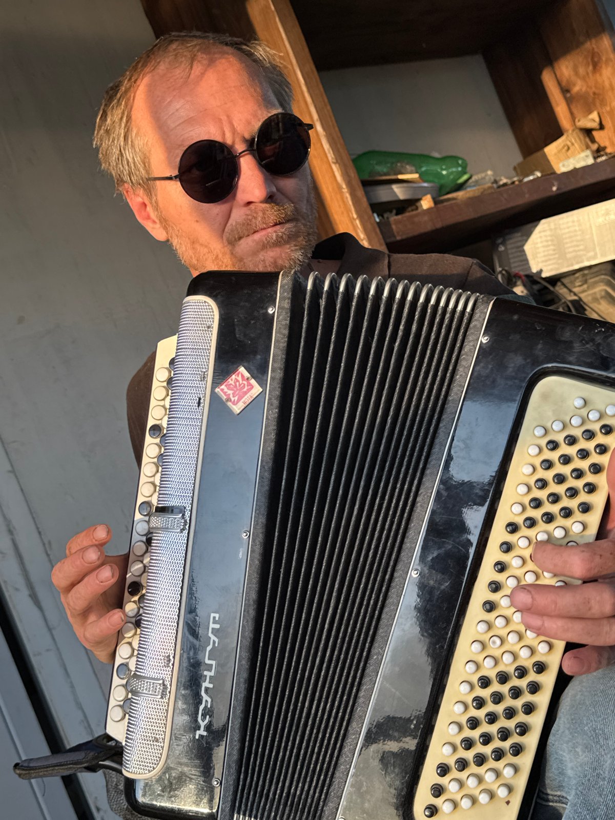 Backyard jam session with accordion, guitar, and a boxer dog