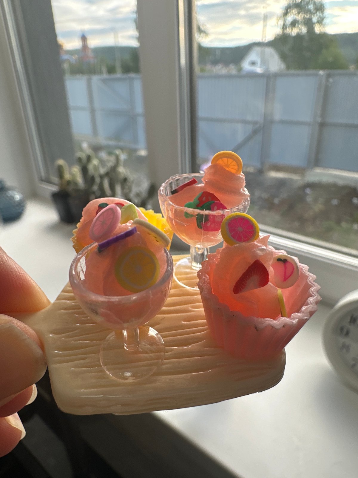 Cat examines miniature dessert decorations in indoor display session