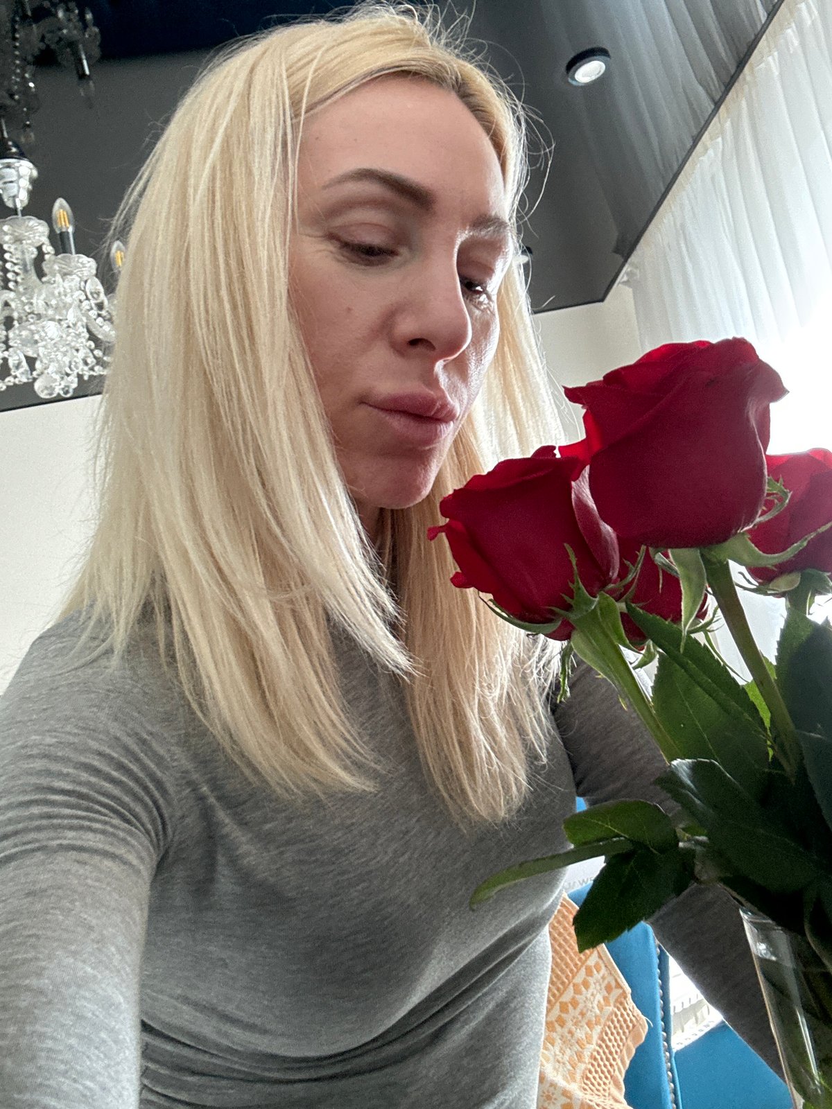 Woman photographed with red roses indoors in Russia