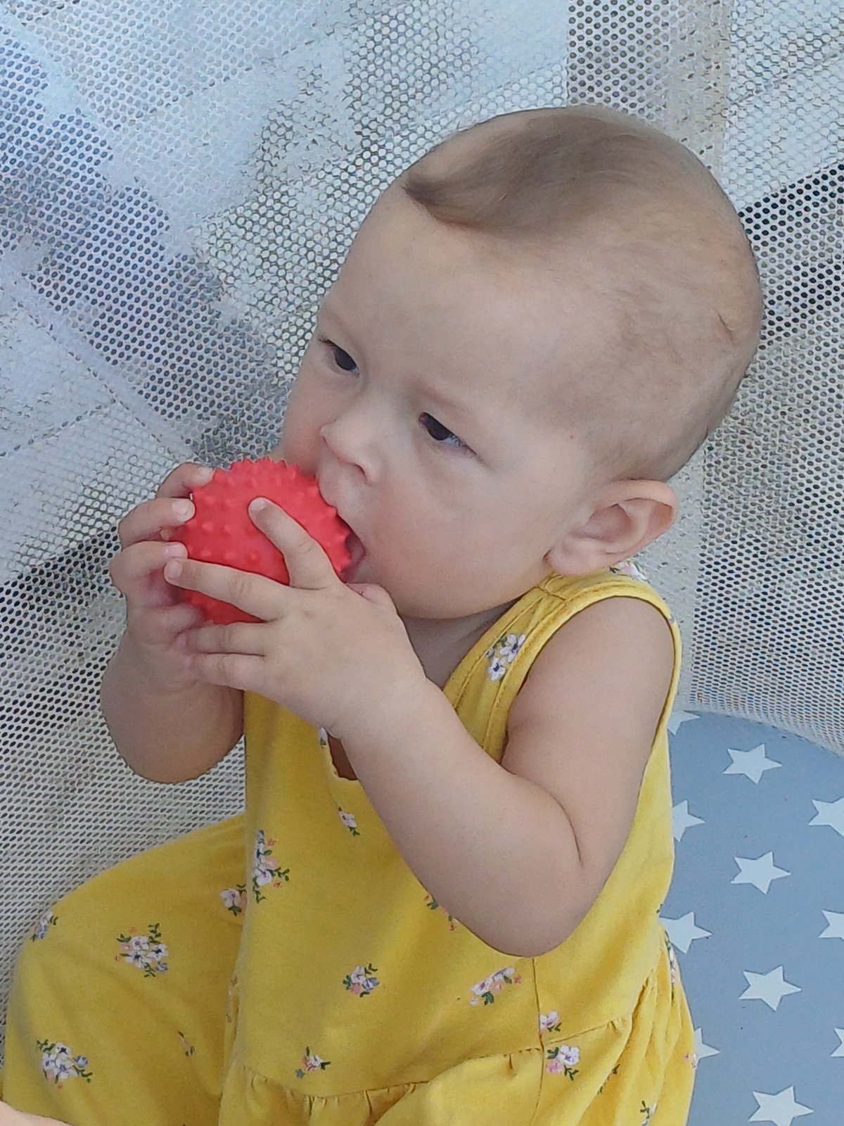 Two kids play outdoors and in a playpen on a Sochi summer day