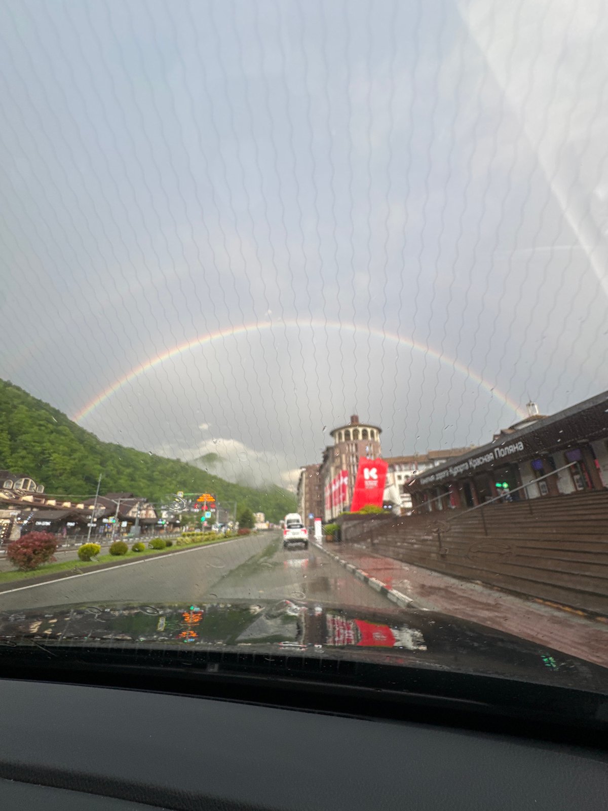 Rainbow appears over Russian mountain resort during afternoon rain