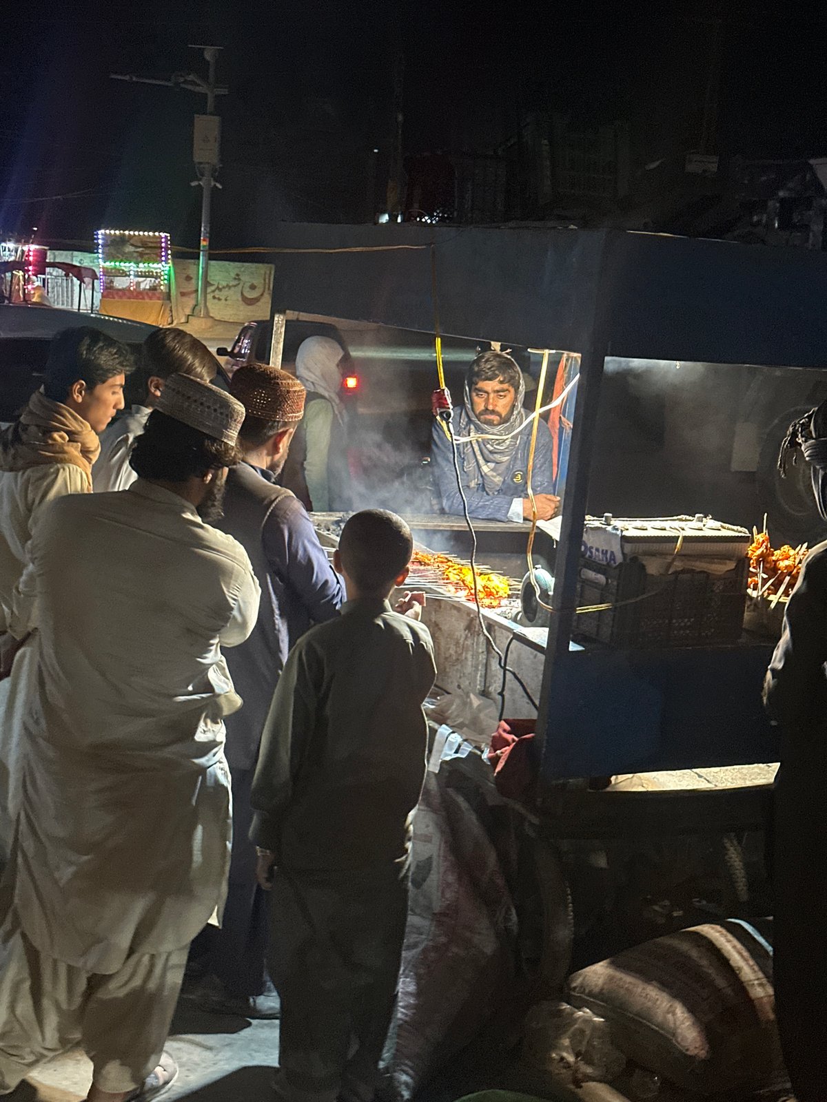 Evening market vendors serve customers in Quetta City