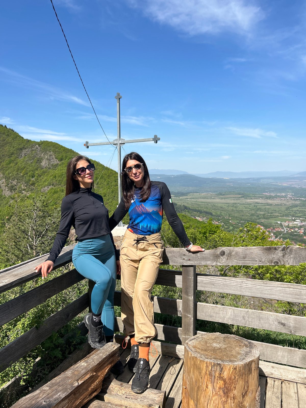 Two women sit on wooden structure in Dupnitsa