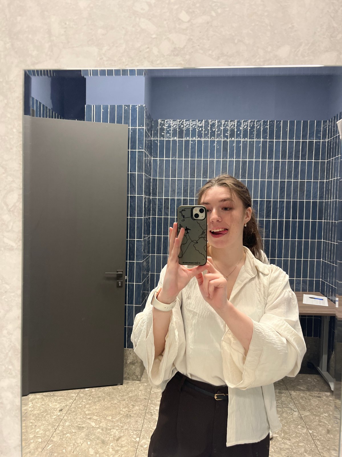 Woman Takes Mirror Selfie in Blue-Tiled Moscow Bathroom